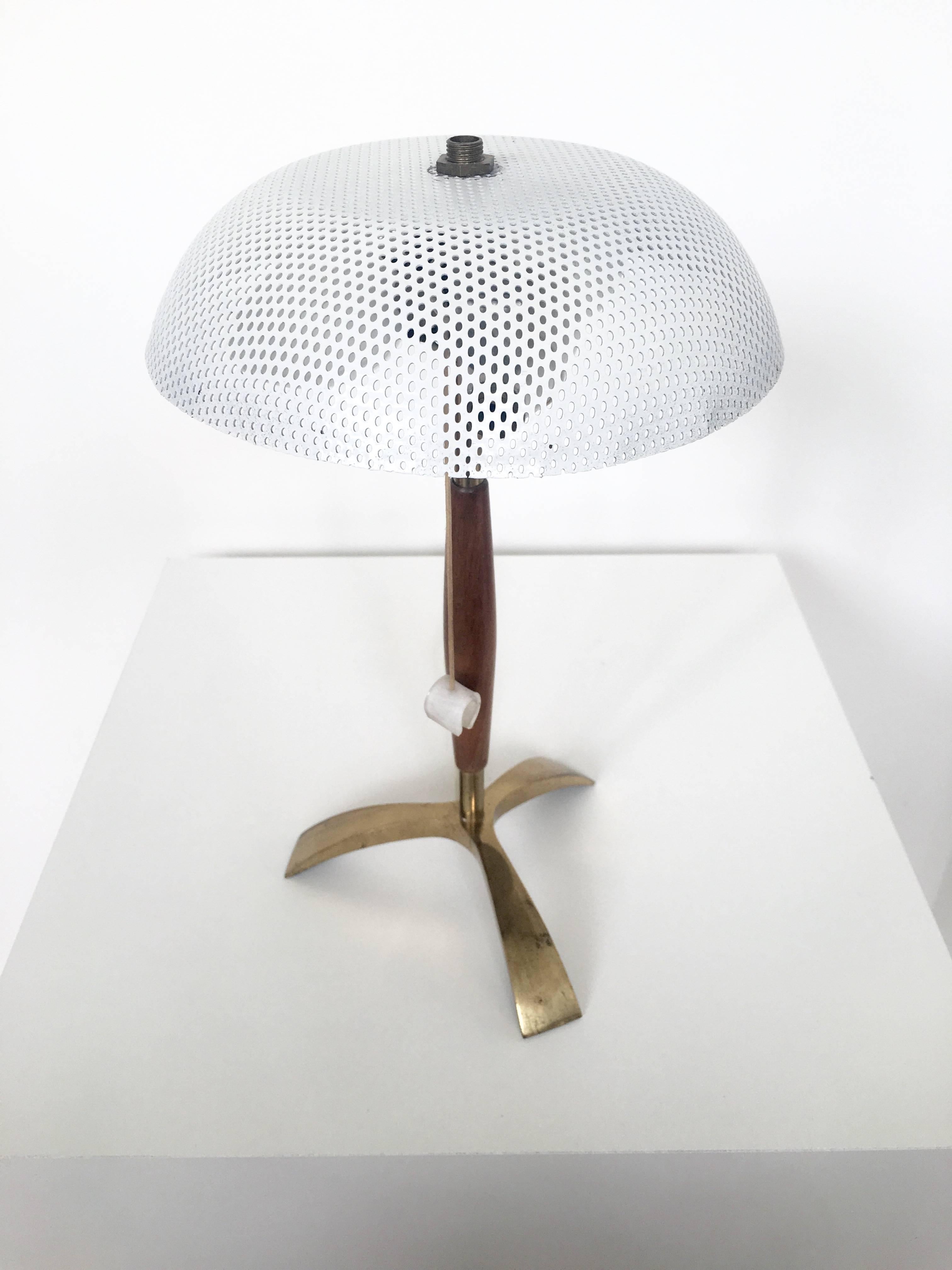 An adorable and unique small French lamp in the style of Mathieu Matégot. The lampshade is a white perforated metal and the base is a simple modern design in brass and wood. The lamp is in it's original wiring and takes two candelabra bulbs.