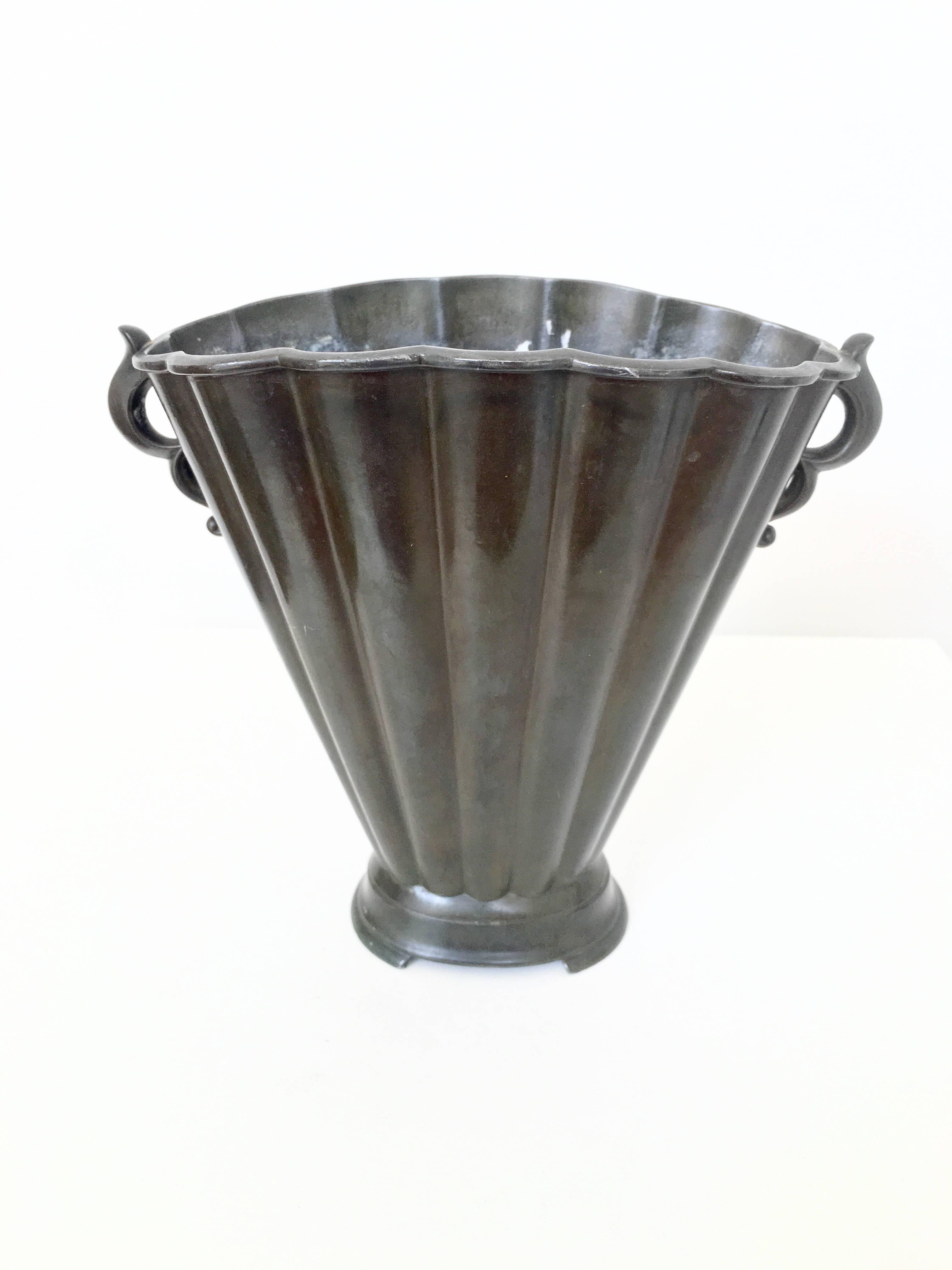 A substantial and gorgeous Disko metal vase by Just Andersen. The fluted vase has beautiful details including a scalloped edge on the top and pair of beautifully detailed handles.