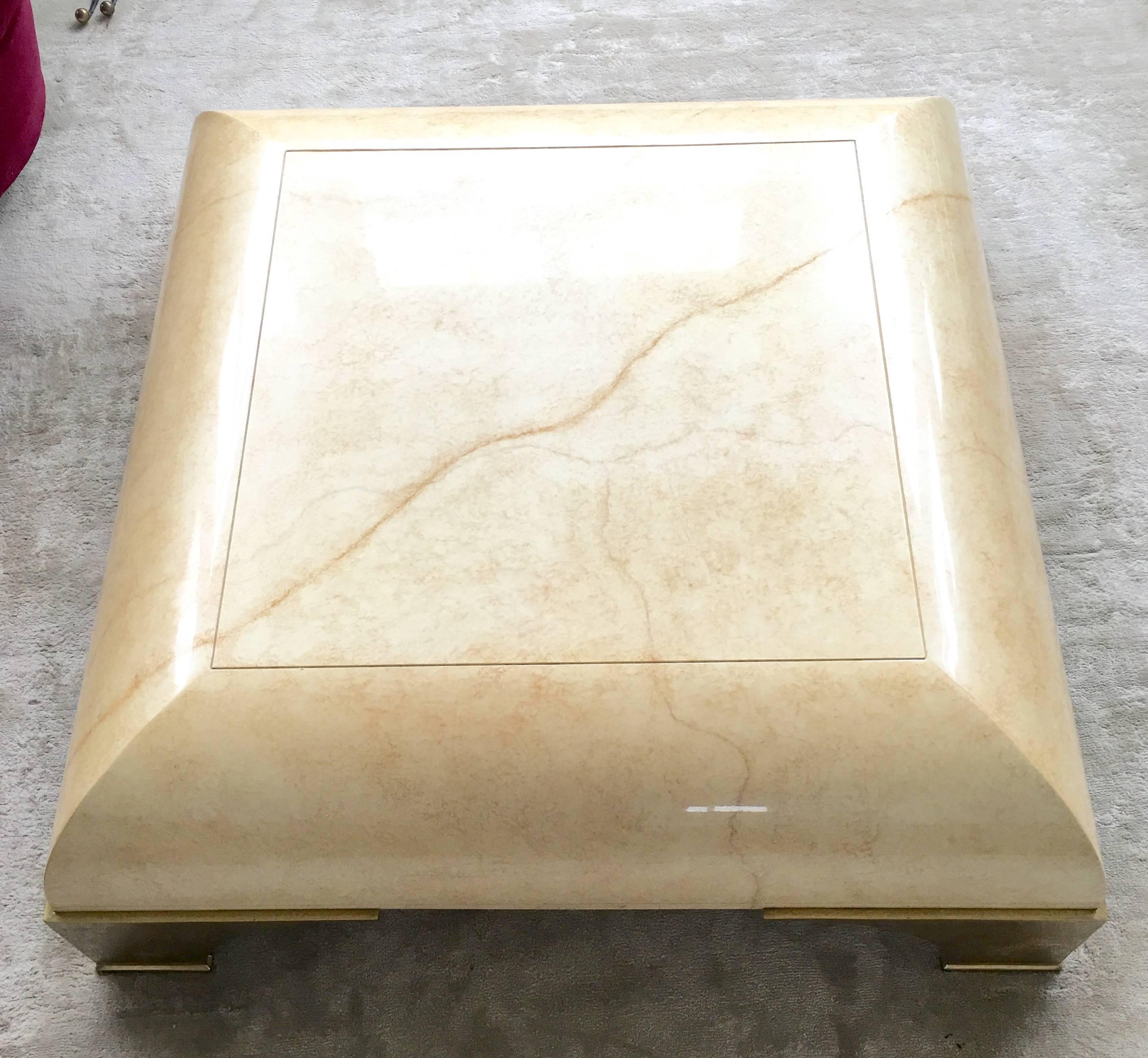 An amazing parchment like finish coffee table with brass feet. The enormous scale of the table is pretty fantastic and actually doesn't belly the beauty of the table. Very much in the style of Marge Carson, Willy Rizzo or Milo Baughman. Great