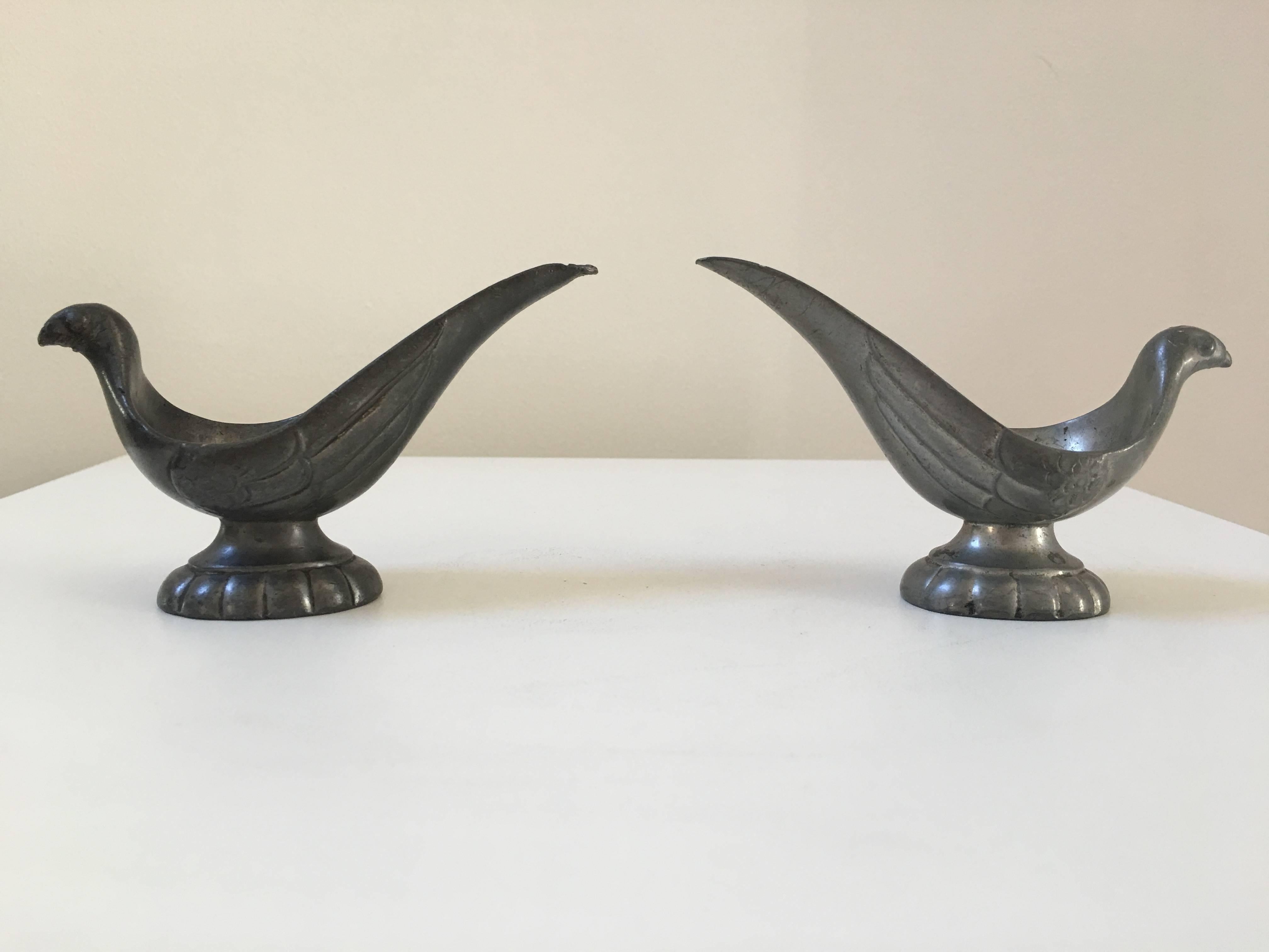 Whimsical and sculptural pair of pipe holders in the form of stylized birds. Made of pewter, both pipe holders are signed. One is slightly darker than the other.