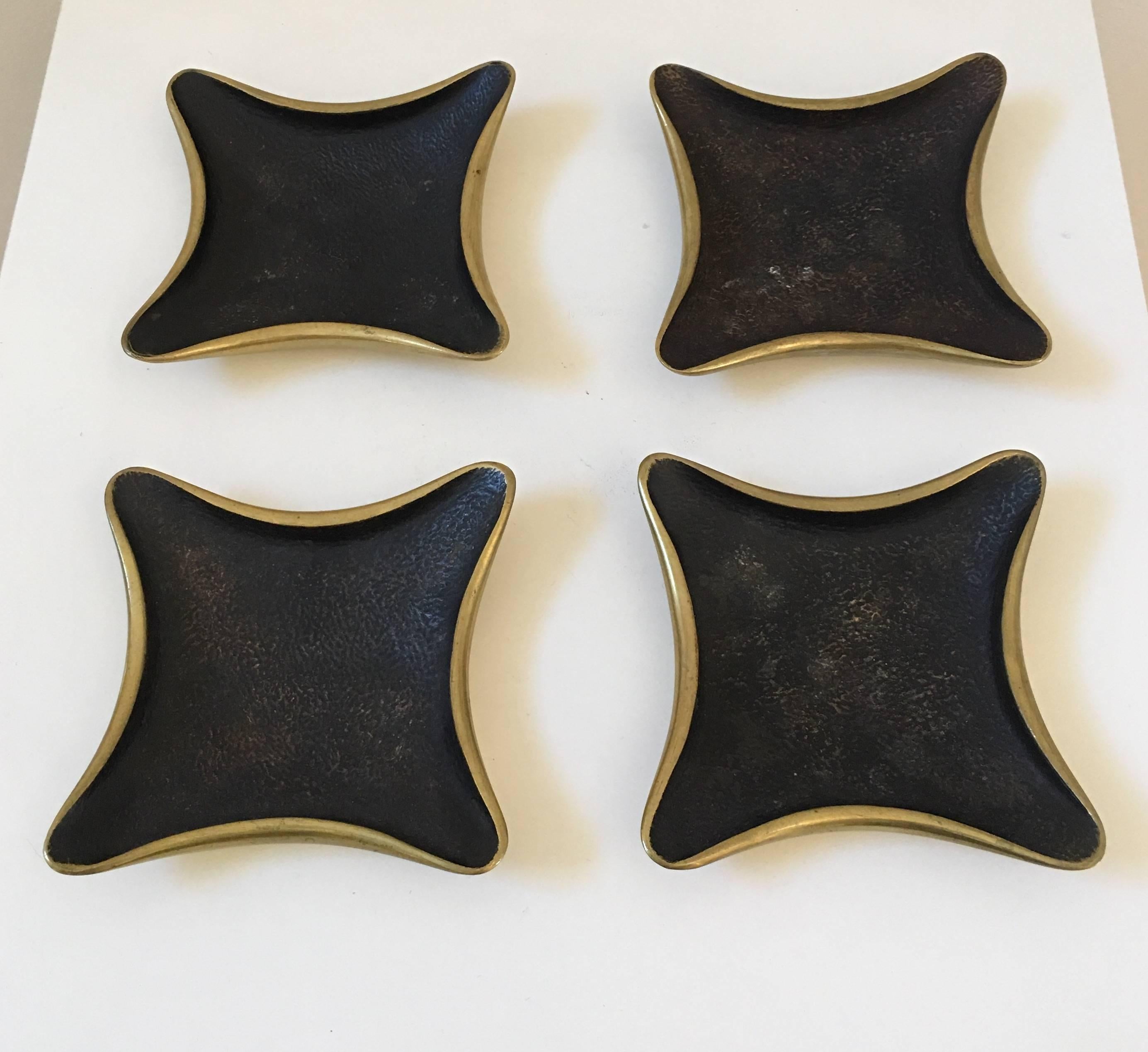 A fabulous and sculptural set of four Wiener Werkstatte trays by Karl Hagenauer. These stylized brass trays are substantially heavy and very well-made with a hand hewn quality typical of the Arts & Crafts and Art Deco periods. The blackened and