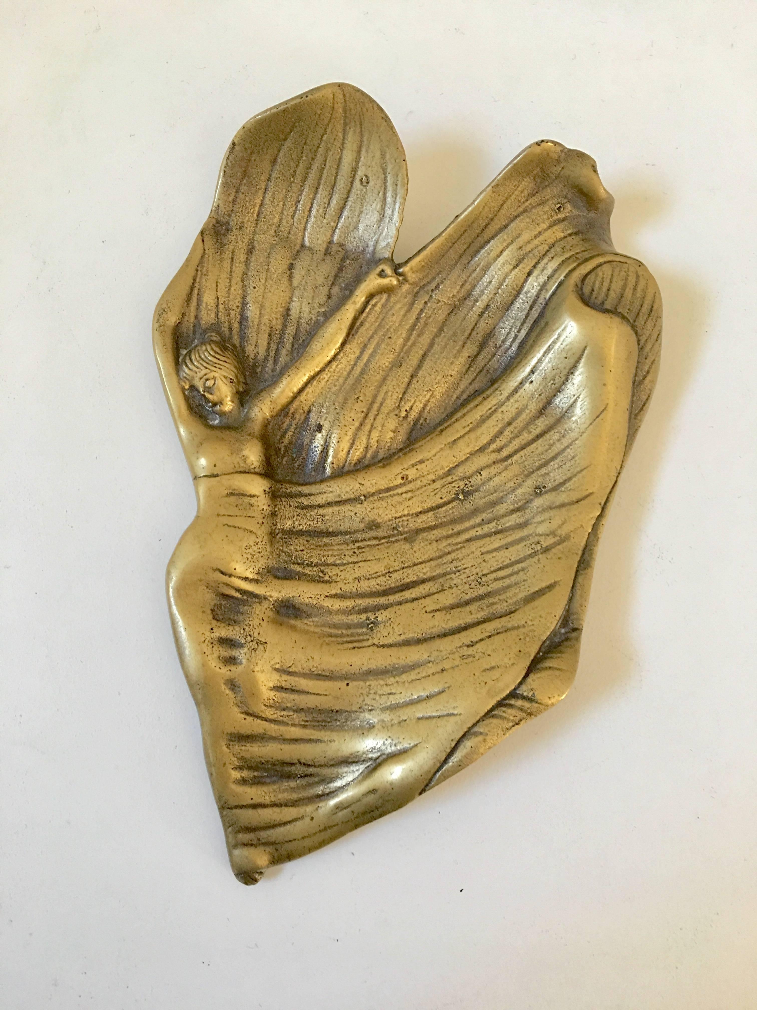 A lovely small, brass tray in the form of a girl with flowing fabric in the form of a leaf or flower petals. Stamped in the bottom.