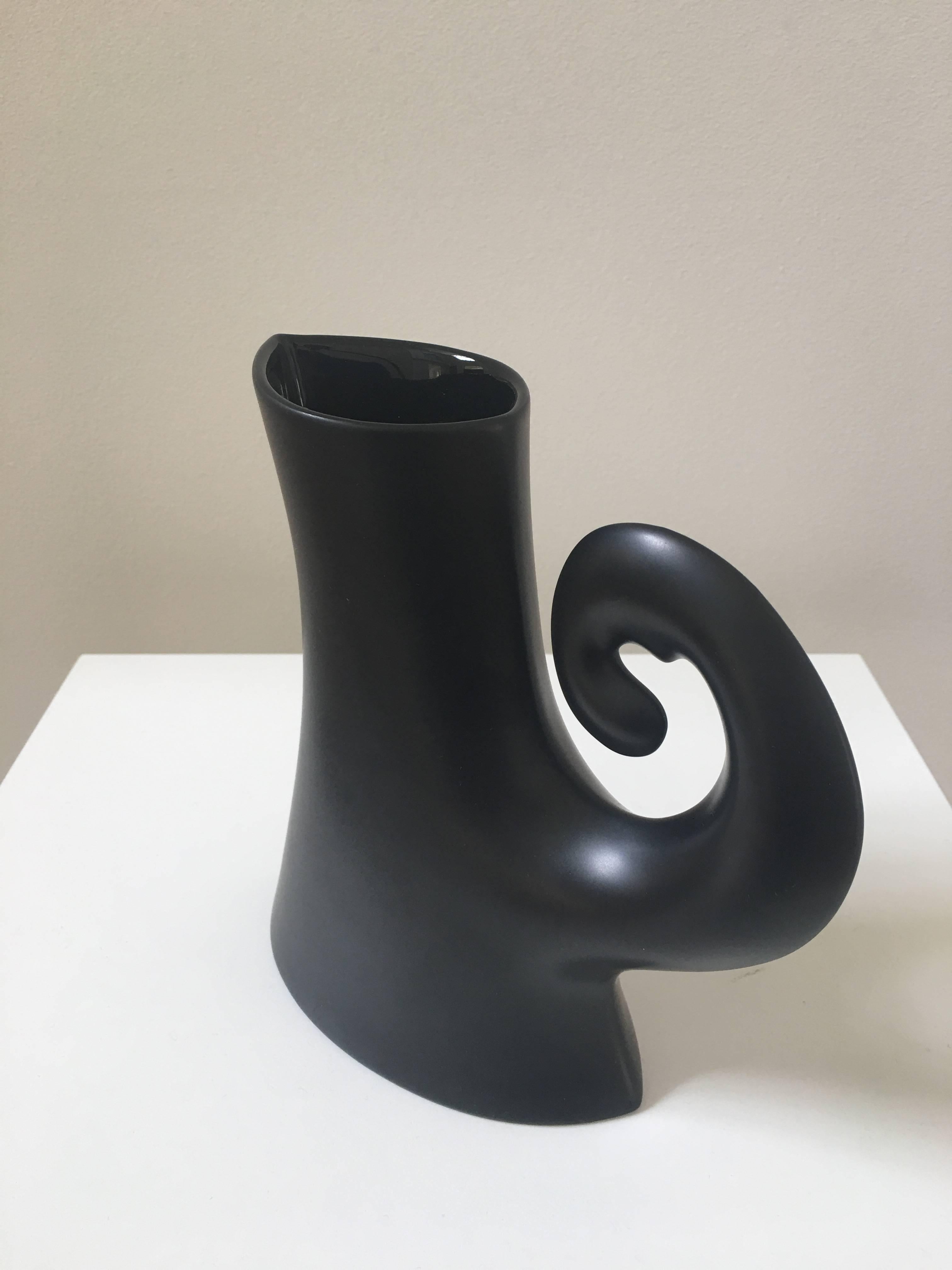 With the most wonderful curly handle, the design of this pitcher is pure fantasy. Aptly made in black the pitcher forms a sculptural silhouette and is almost new.