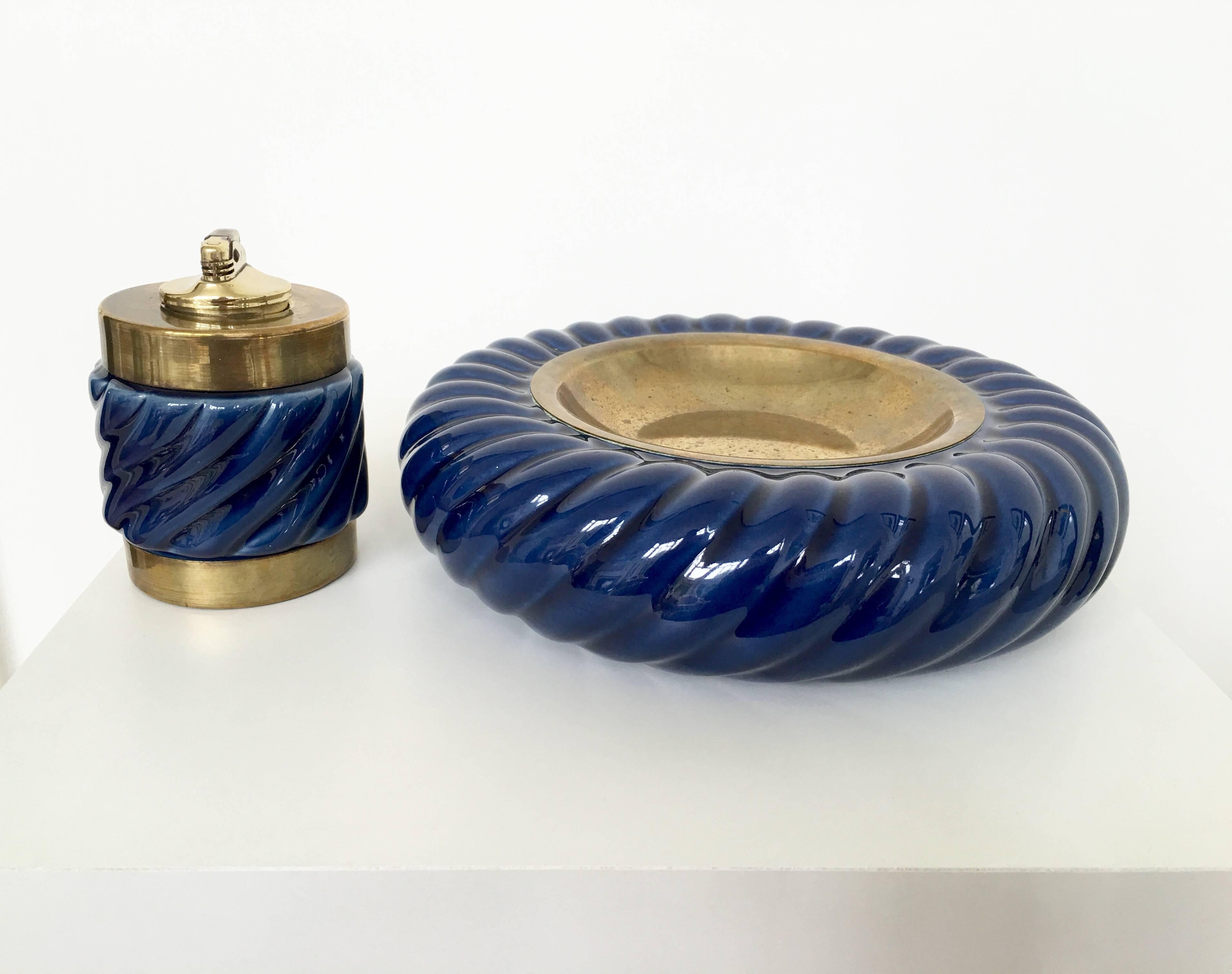 A fabulous set of ashtray and lighter by Tommaso Barbi. Very decorative and collectible the combination and contrast of the blue ceramic and brass fittings are absolutely lovely.

Dimensions of lighter:
Height: 4