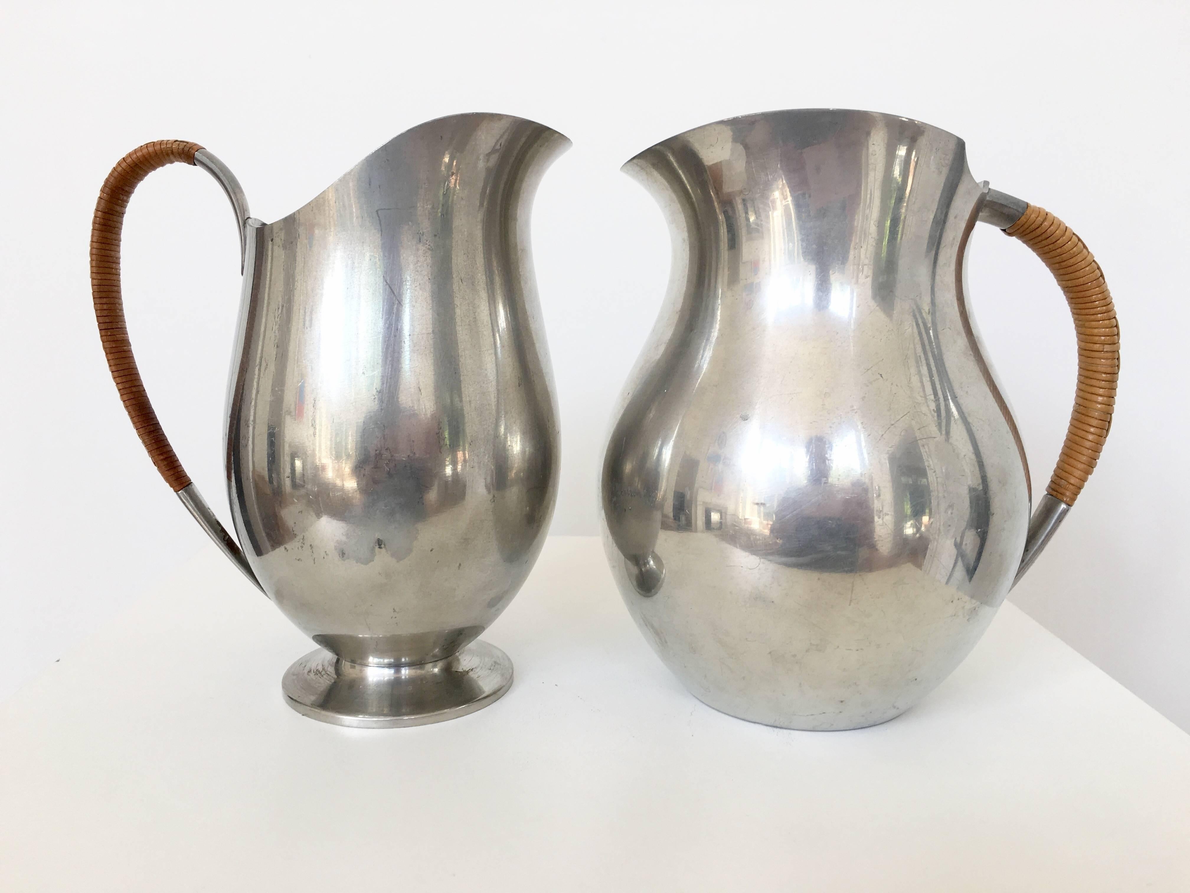 The forms of these two pitchers couldn't be better. They are both wonderful to hold and use. The body is entirely made of pewter and the handles are wrapped in wicker giving them a terrific design detail. Each pitcher is a bit different in size and