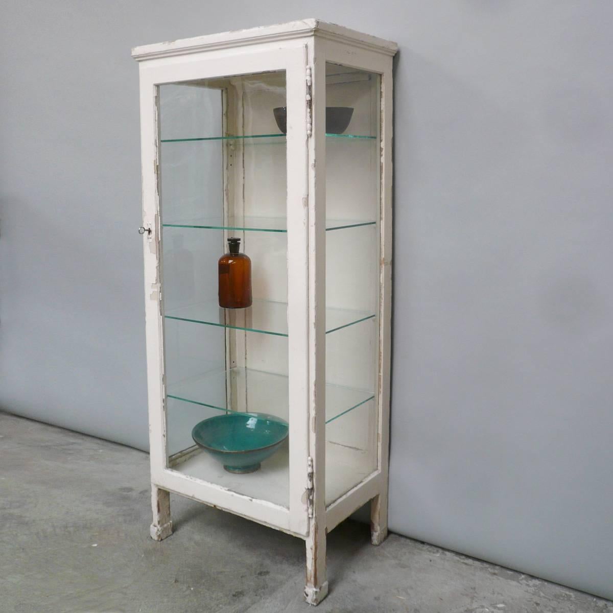 Medical wooden cabinet, produced in the 1930s. The glass is the original antique glass. With four glass shelves. The lock and key work perfectly.