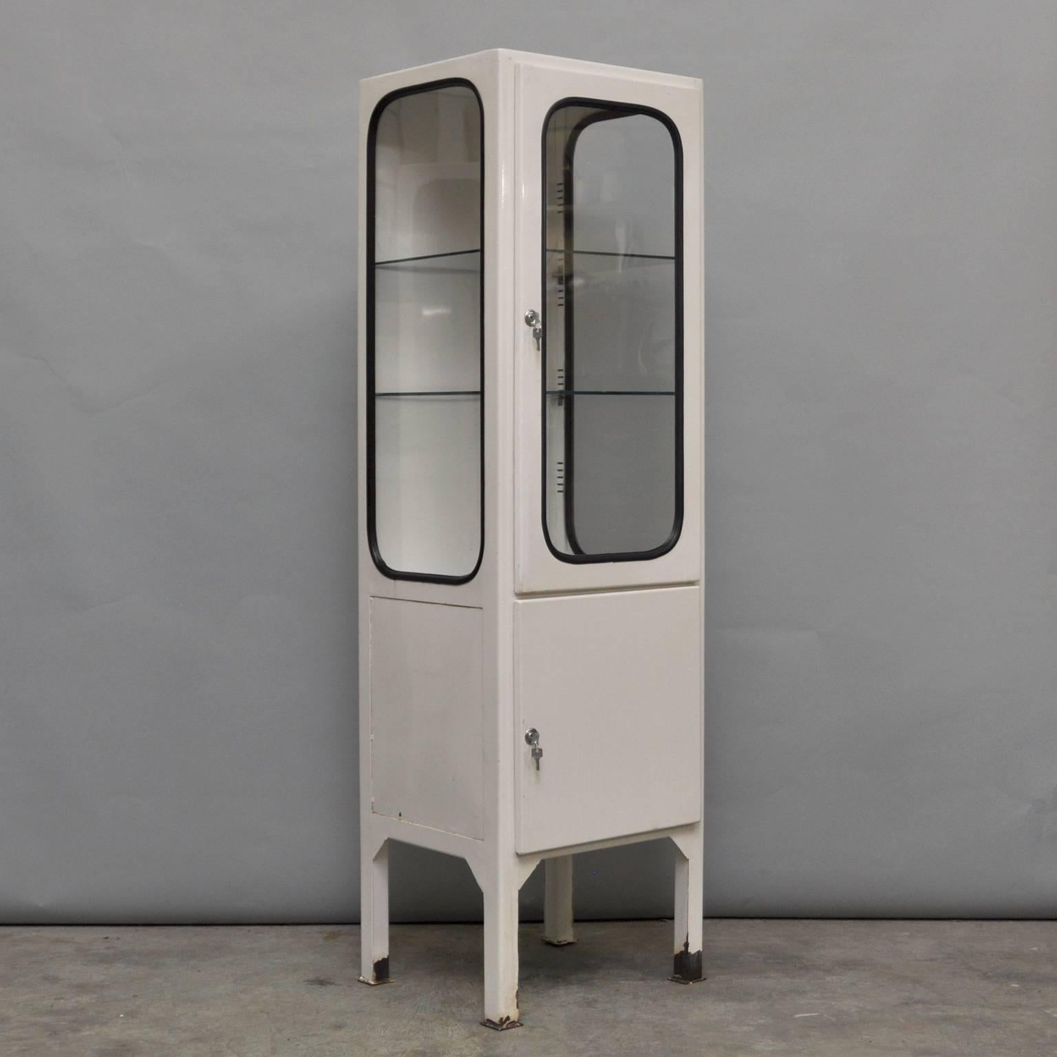 This medicine cabinet was designed in the 1970s and produced circa 1975 in Hungary. Made from steel and glass, the glass is held in place by a black rubber strip. The cabinet arrives with two adjustable glass shelves and a functioning locks.