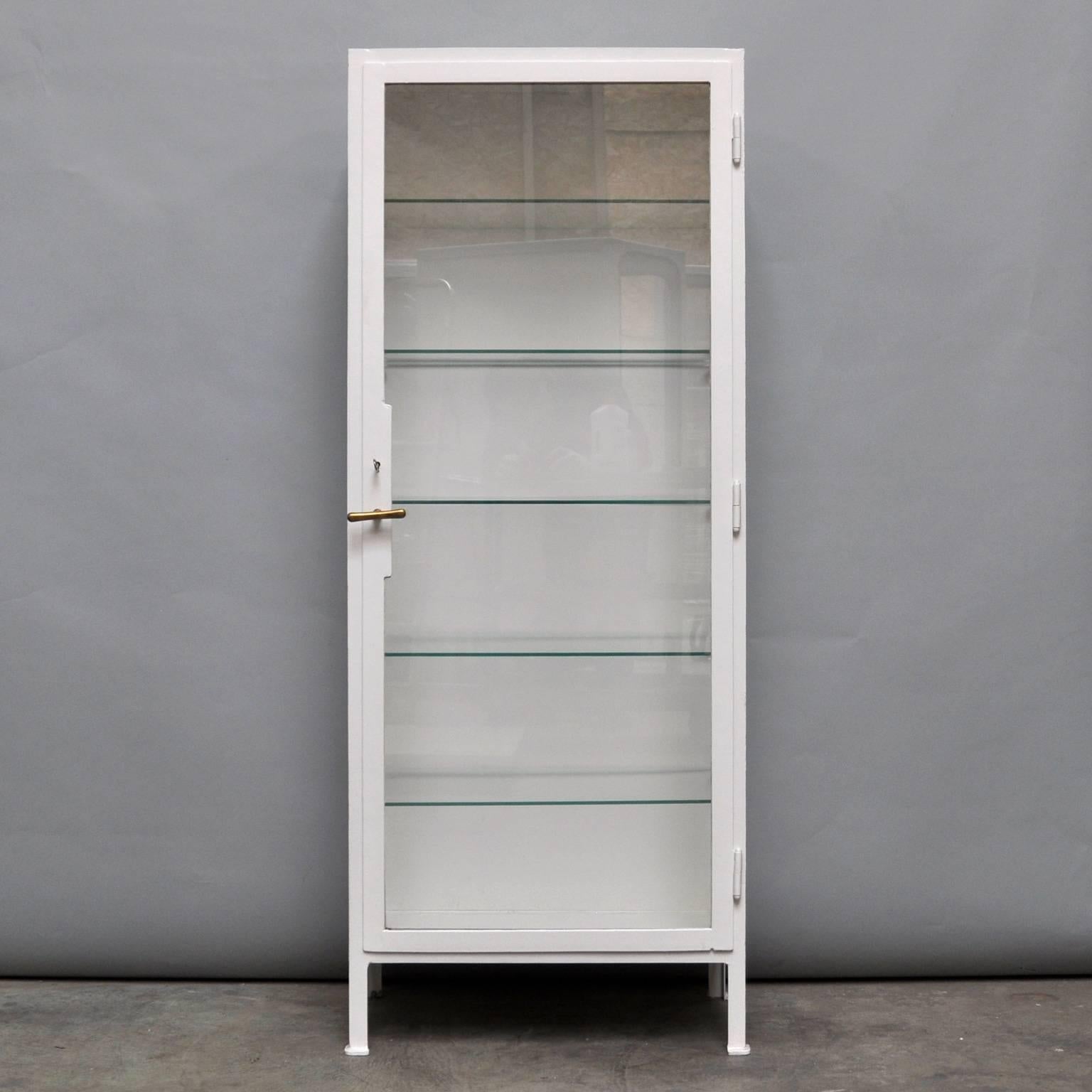 This medicine cabinet was produced circa 1945 in Hungary. The cabinet is made from thick iron and glass, and features five glass shelves. In an excellent condition, the piece has been restored.