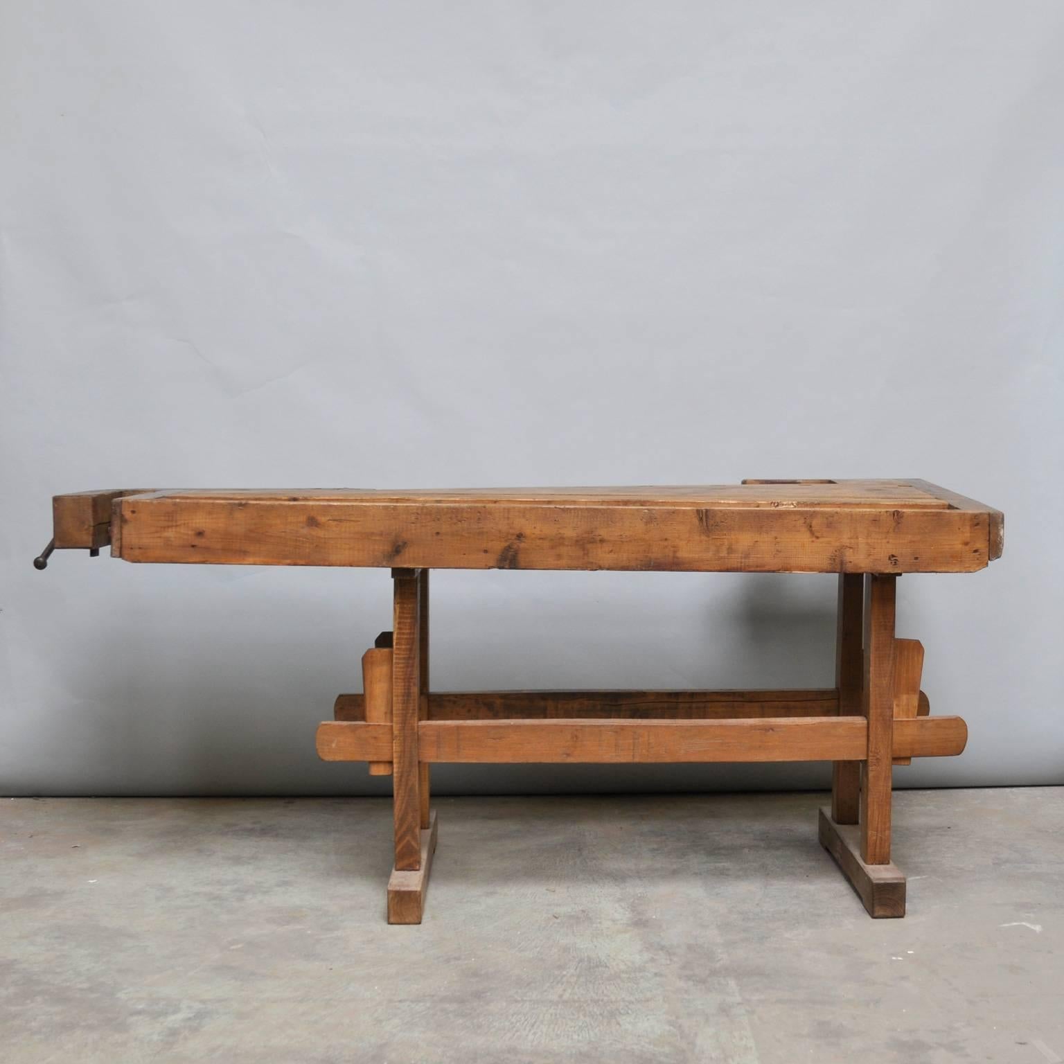 This vintage Hungarian carpenter’s workbench features two vices with a iron handle and a recessed tray where the carpenter would lay his tools. It was manufactured, circa 1935.