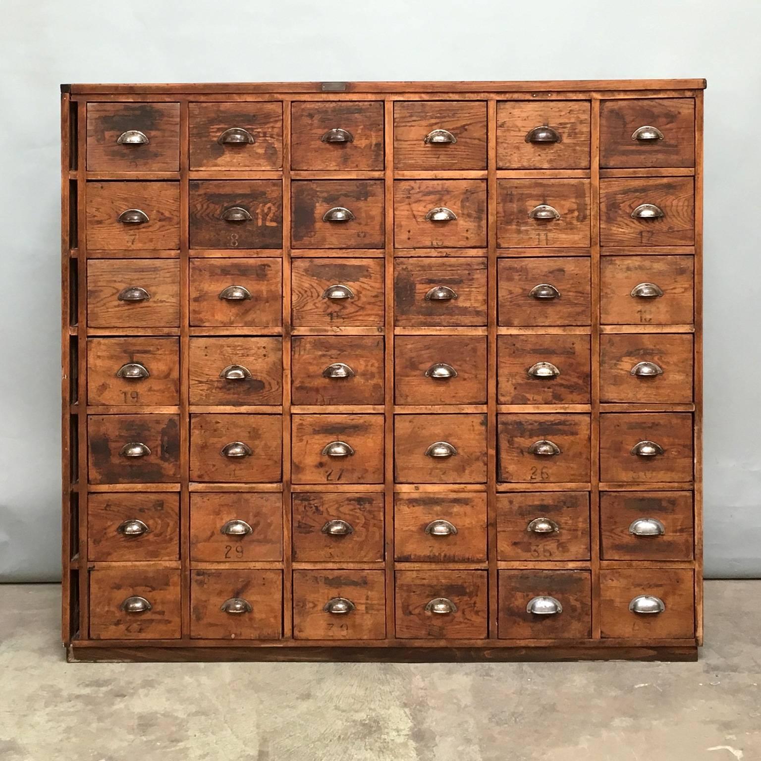 This Industrial pine wooden tool cabinet was designed during the 1930s and manufactured in Hungary. This cabinet features a pinewood frame with six columns of seven drawers. It is in a good vintage condition with signs of use.