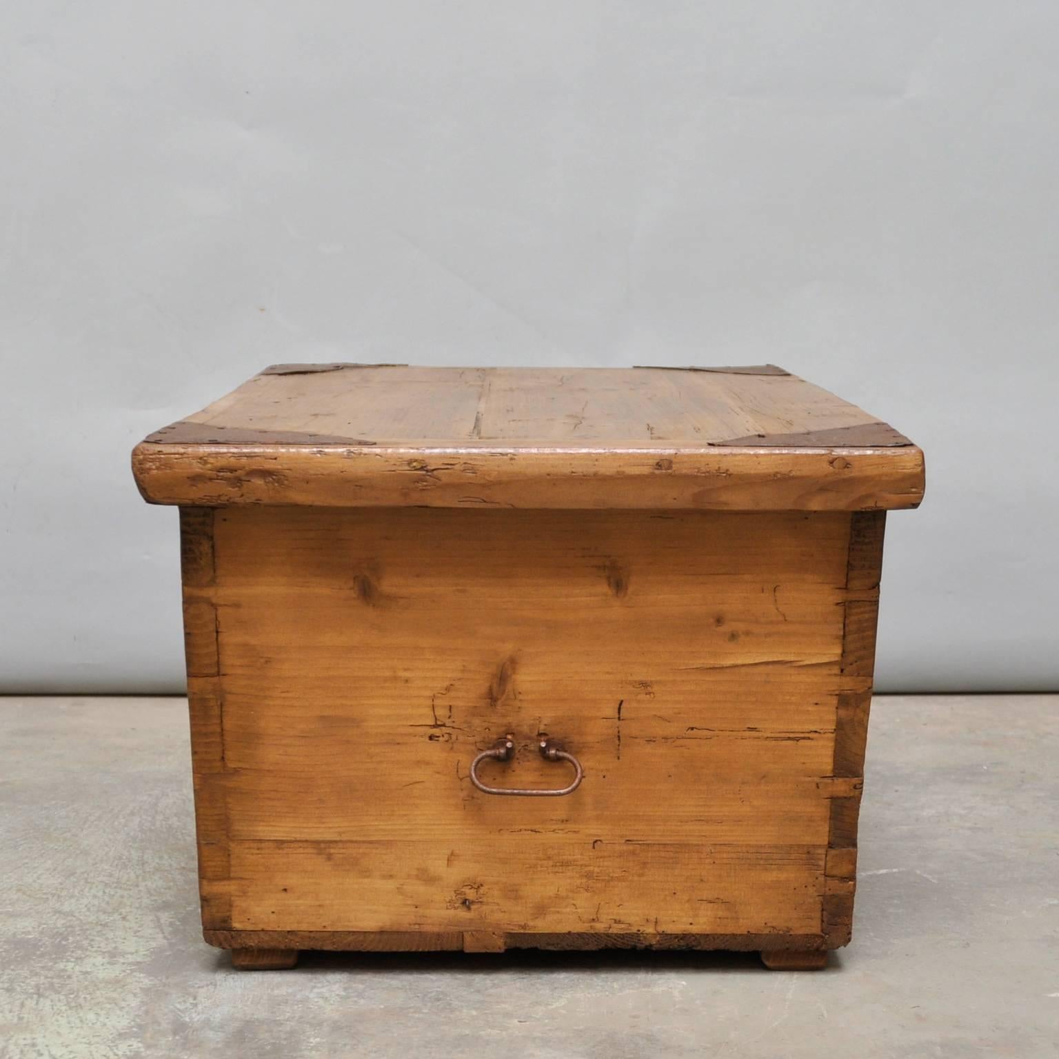This wooden chest was made for a wagon. That explains the unusual shape. The chest is made of pine and iron with a wax finish. It was made in the 1930s.