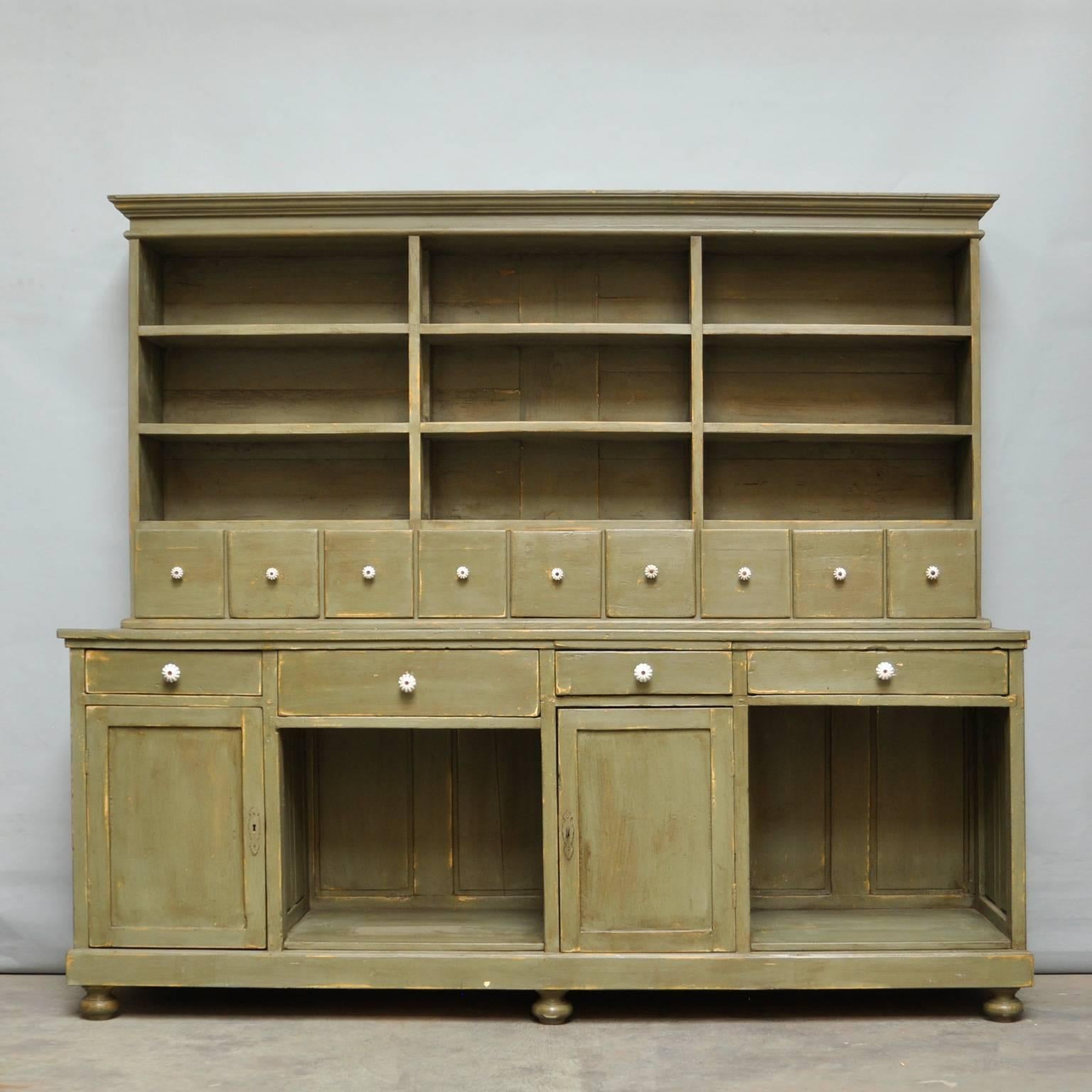 Painted cupboard from the 1930s made of pine with eight drawers on top and two doors and four drawers on the bottom case. The cabinet is build up in two parts (bottem and top).