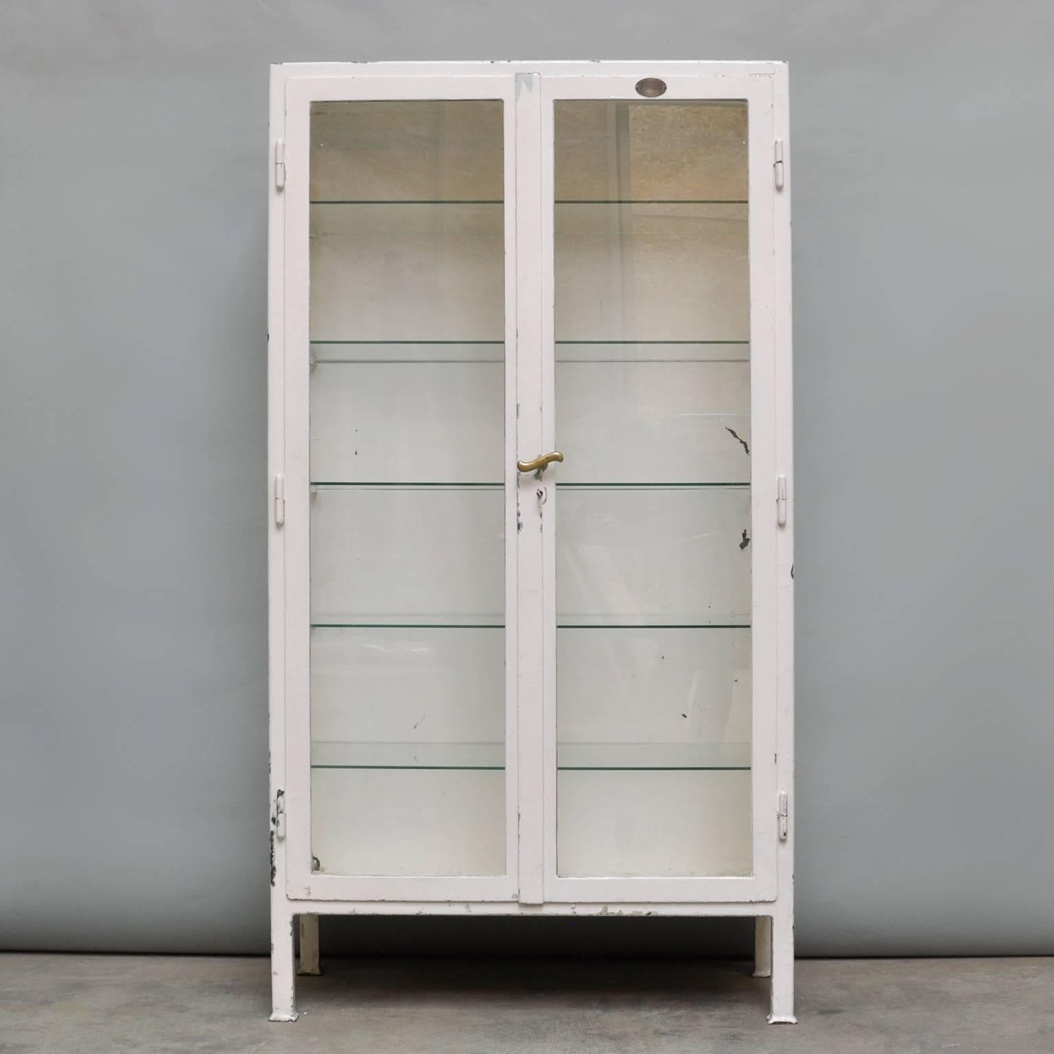 Medical cabinet, produced in de 1930s in Budapest, Hungary. The cabinet is made of thick iron and antique glass. On the label on the front of the cabinet the text: 'MONE, medical instrument and plant equipment, Budapest'. The five glass shelves are