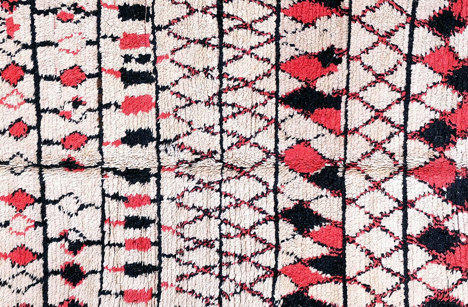 Beautiful Berber carpet from Morocco. This carpet is a real old hand-knotted one from naturally dyed wool. This rug is characterized by an abstract geometric motif, in this case: black and red diamonds and lines. The Berber carpets are very warm,