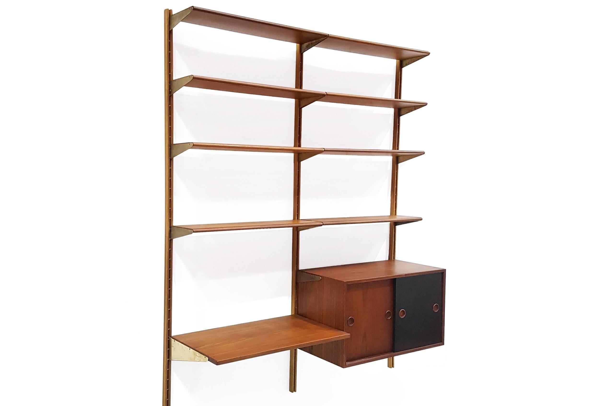 Teak wooden wall unit designed by Finn Juhl and produced by Bovirke Denmark, in the 1950s.
This wall unit offers a cabinet with two sliding doors, one deep shelf which can be used as a desk (45 cm deep) and eight shelves.
The shelves are wonderful