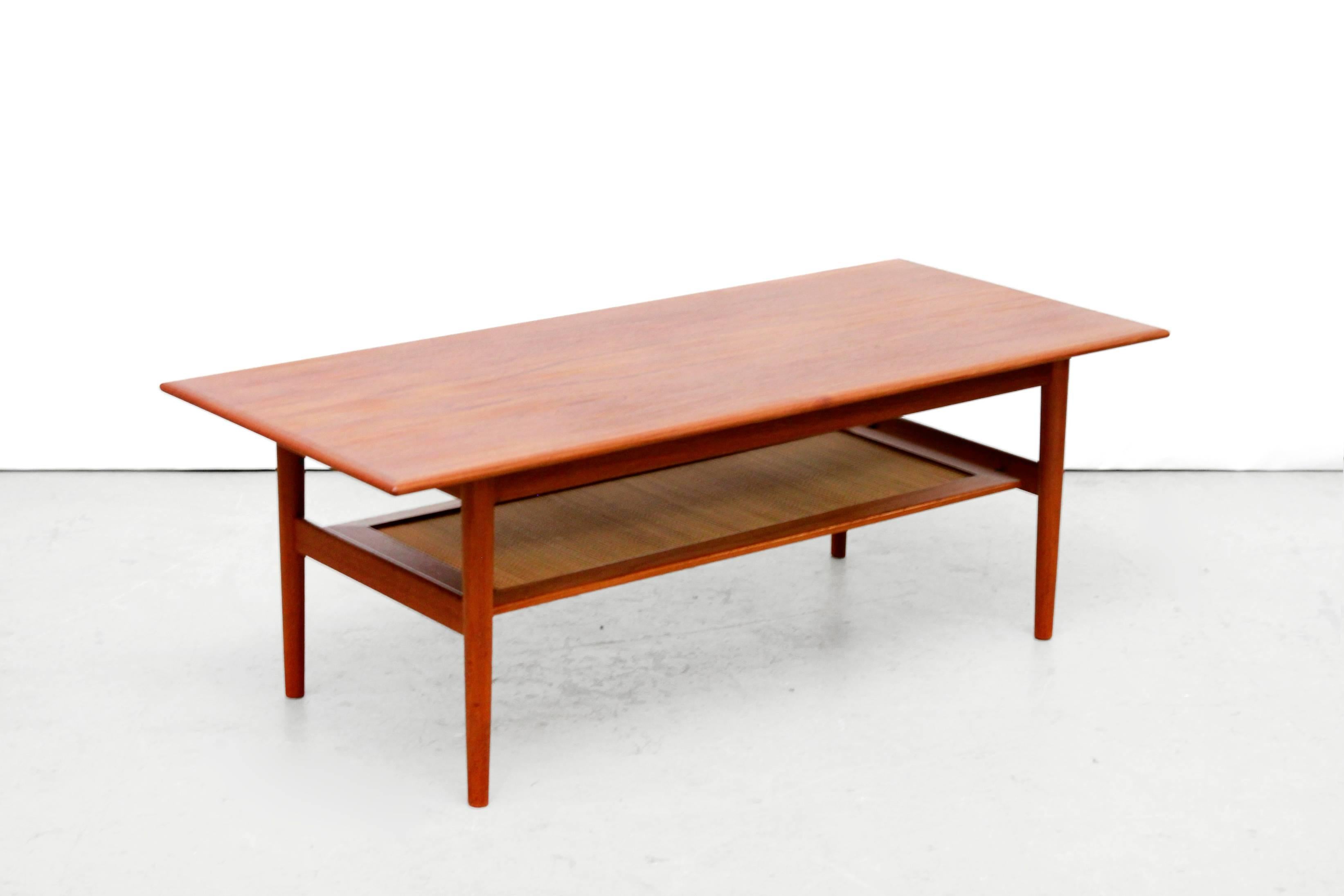 This Minimalist coffee table was designed by Peter Hvidt and Orla Mølgaard Nielsen for France and Son. The coffee table is made from solid teak and teak veneer with a cane lower shelf for magazines.
Brass parts, cane all in very good condition.