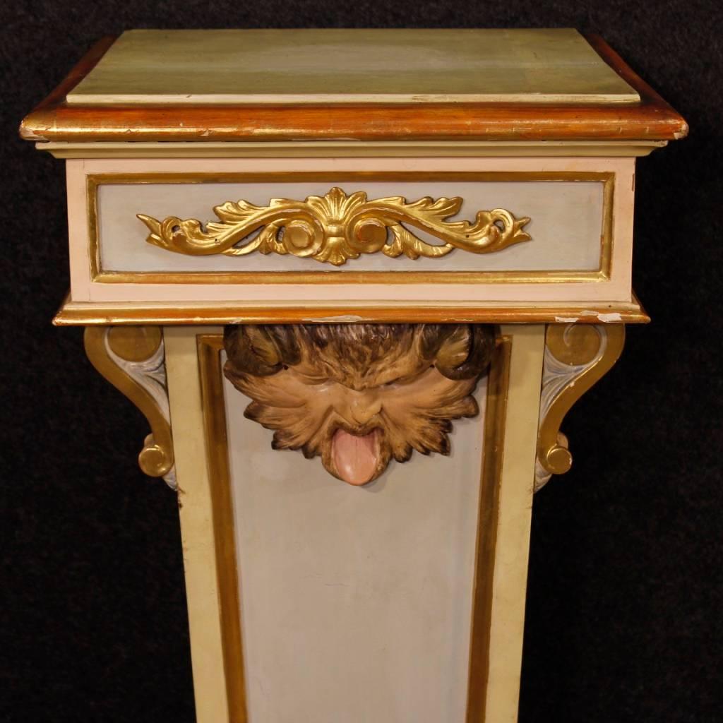 Italian column of the early 20th century. Furniture in carved, lacquered and golden wood of good quality. Column decorated with gilded friezes in relief and painted masks of fabulous decoration. Furniture finished for the center ideal for supporting