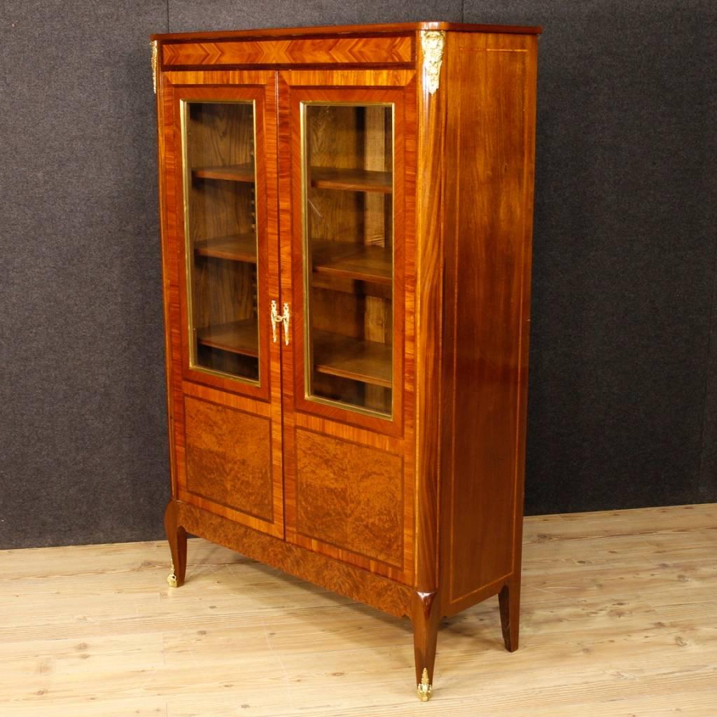 French vitrine of the 20th century. Furniture inlaid in mahogany, rosewood, burl, walnut and cherrywood. Bookcase with two doors, complete with a working key, of great capacity and service. Interior with three shelves repositionable at different