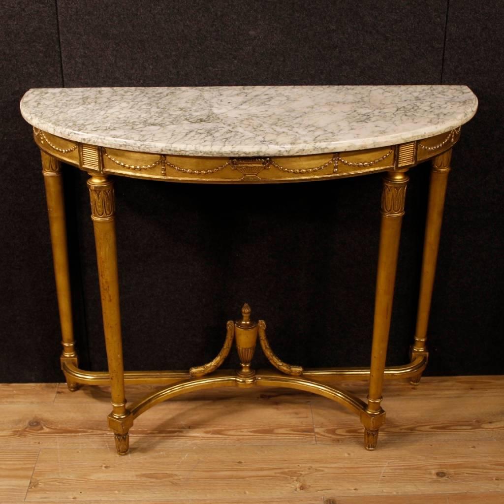 French demilune console of the mid-20th century. Furniture in nicely carved and gilded wood and plaster in Louis XVI style. Elegant neoclassical console table with original marble top in perfect condition. Furniture of very good proportion and good