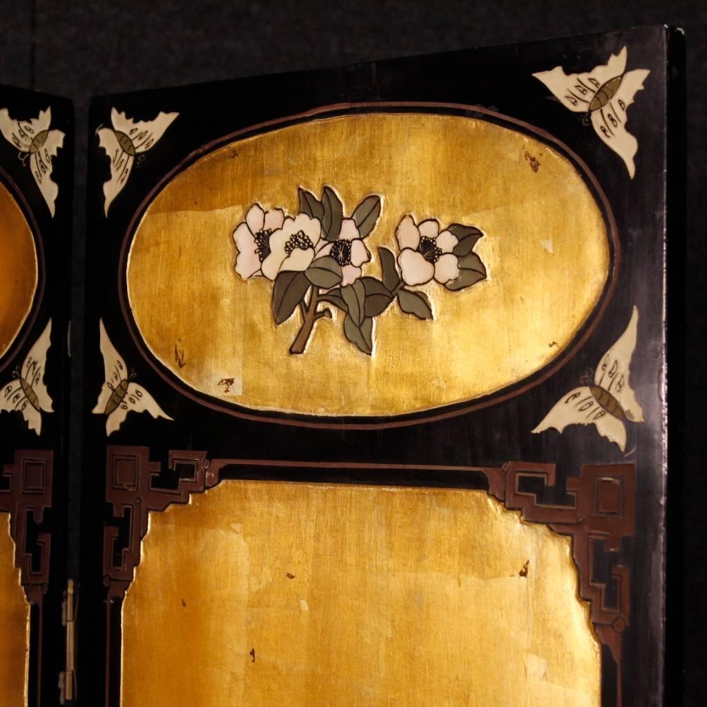 French screen of the mid-20th century. Furniture in richly lacquered, golden and chiseled wood with floral decorations and Chinese ornaments. Screen with four panels finished for the center, ideal for inserting into a living room or bedroom.