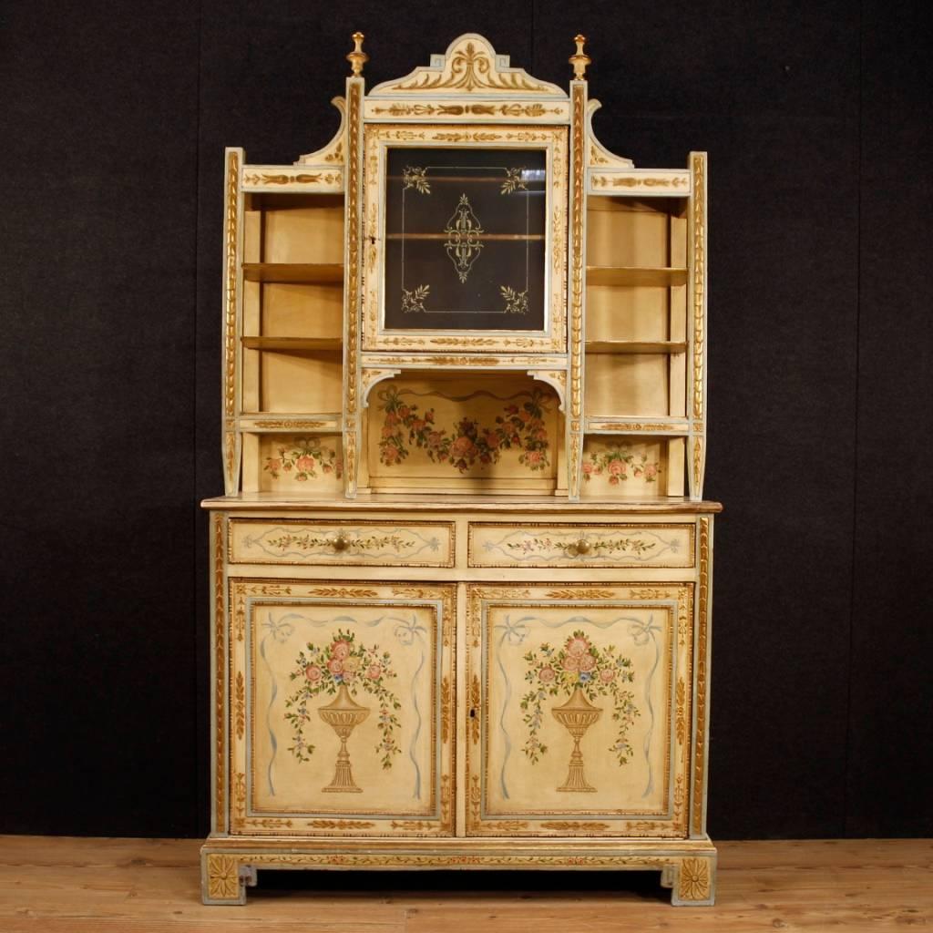Italian cupboard of the 20th century. Double body furniture in carved, lacquered, golden and painted wood with floral decorations.Cupboard of great quality and fabulous decor ideal for a living room or dining room. Furniture with two door and two