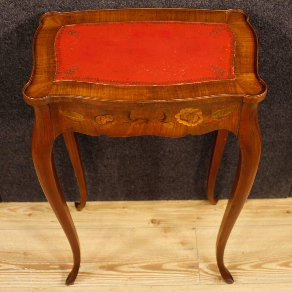 French side table of the 20th century. Furniture of beautiful line, inlaid in mahogany, cherry and fruitwood adorned with floral decorations. Side table with top covered in faux leather, of discreet size and service. Furniture equipped with two side