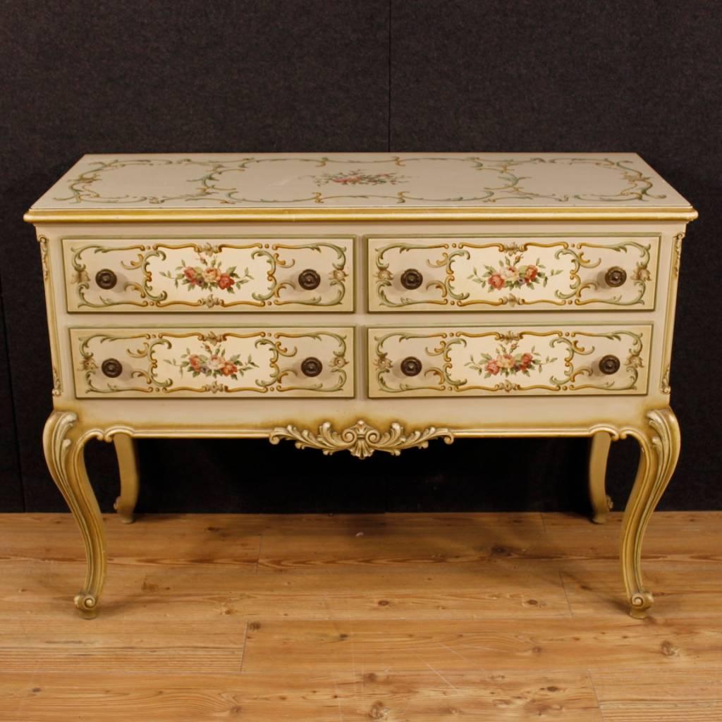 Italian dresser of the 20th century. Furniture in richly lacquered, golden and painted wood decorated with floral decorations. Commode with four external drawers of good capacity and service, ideal for inserting in a bedroom. Chest of drawers with