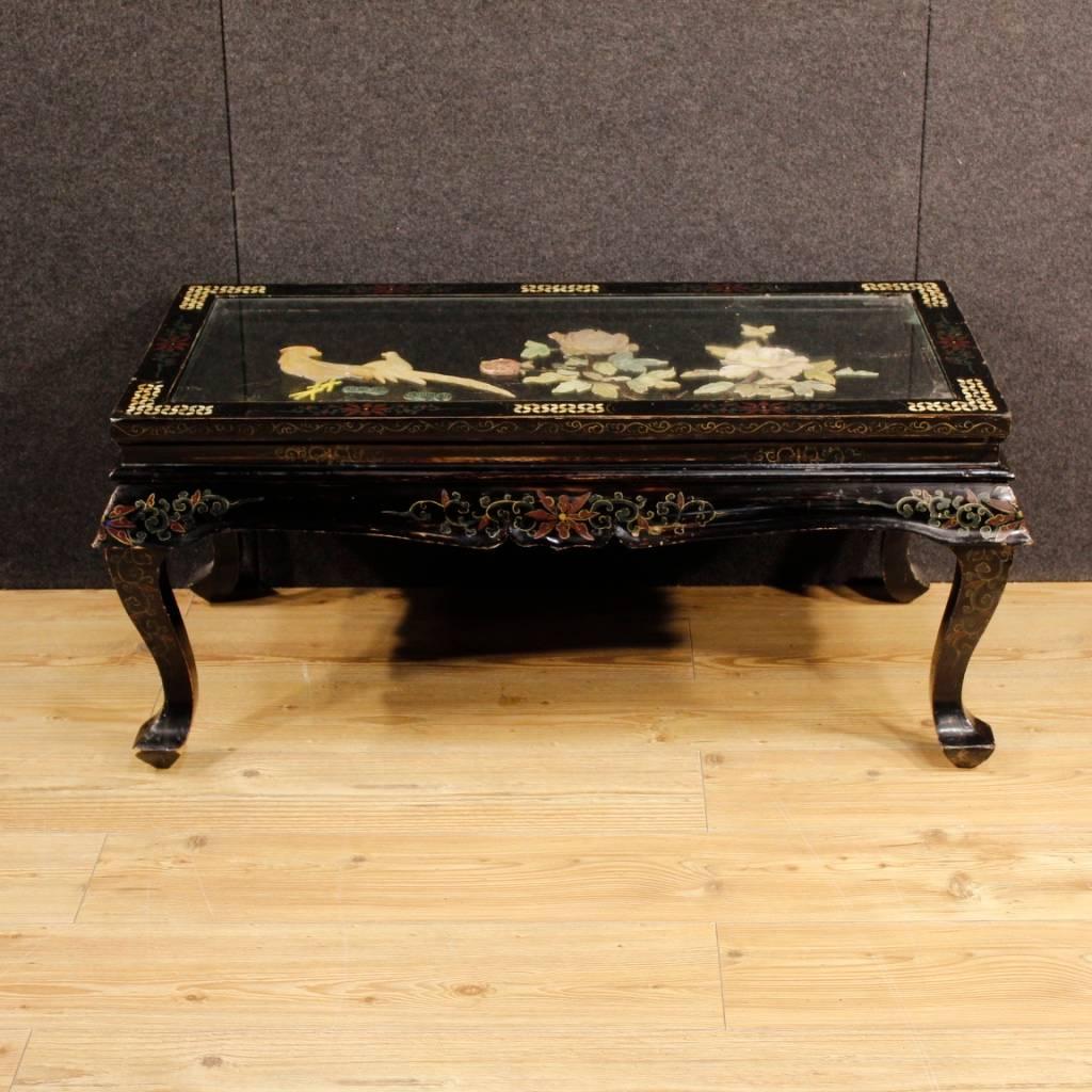 French coffee table of the 20th century. Lacquered and painted chinoiserie furniture with relief decorations in soapstone and mother-of-pearl inlay. Coffee table of good size and service, top floor with recessed glass that has a small chipping, to