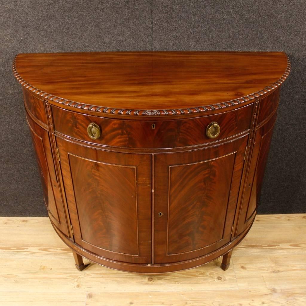 English sideboard of the 20th century. Furniture in mahogany wood of beautiful line and pleasant decor. Sideboard with four doors and a central drawer of excellent capacity. Wooden top floor in character of good size. Missing keys, it has some signs