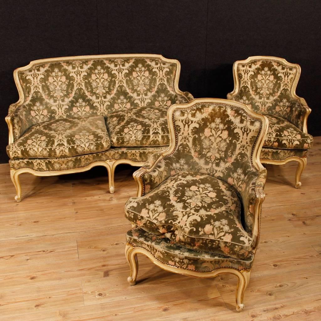 Pair of Italian armchairs of the 20th century. Furniture in carved, lacquered and gilded wood of pleasant decor. Armchairs covered in damask velvet of beautiful decoration with some signs of wear. Padding in good condition that offers a comfortable