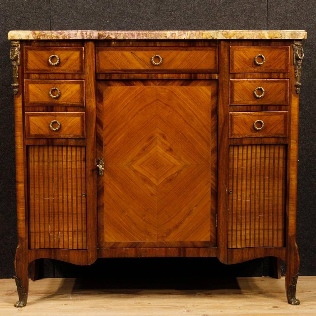French sideboard from the first half of the 20th century. Furniture in mahogany, rosewood, maple and fruitwood pleasantly decorated with gilded and chiselled bronzes. Sideboard with seven external drawers, a central door and two sliding side doors