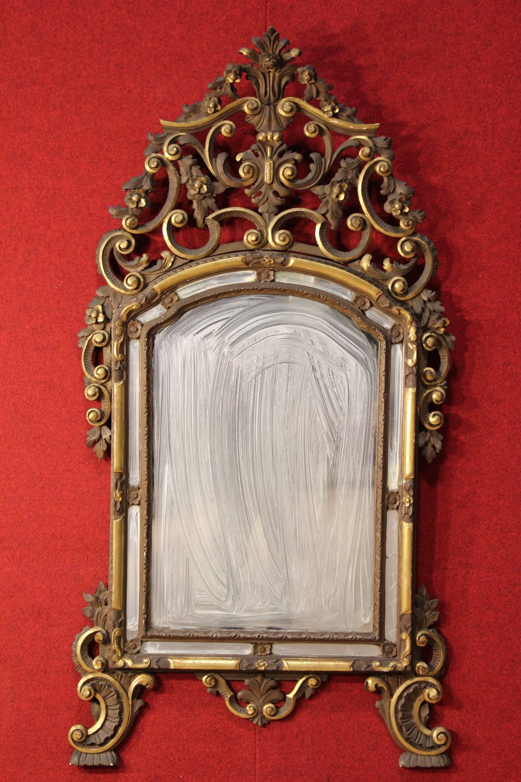 Italian lacquered and gilded mirror. 
Furniture from Turin in Louis XV style richly carved, gilded and painted. Mirror of the 20th century. Furniture decorated with frame with recessed mirrors, one in the lower right corner is broken. It has small
