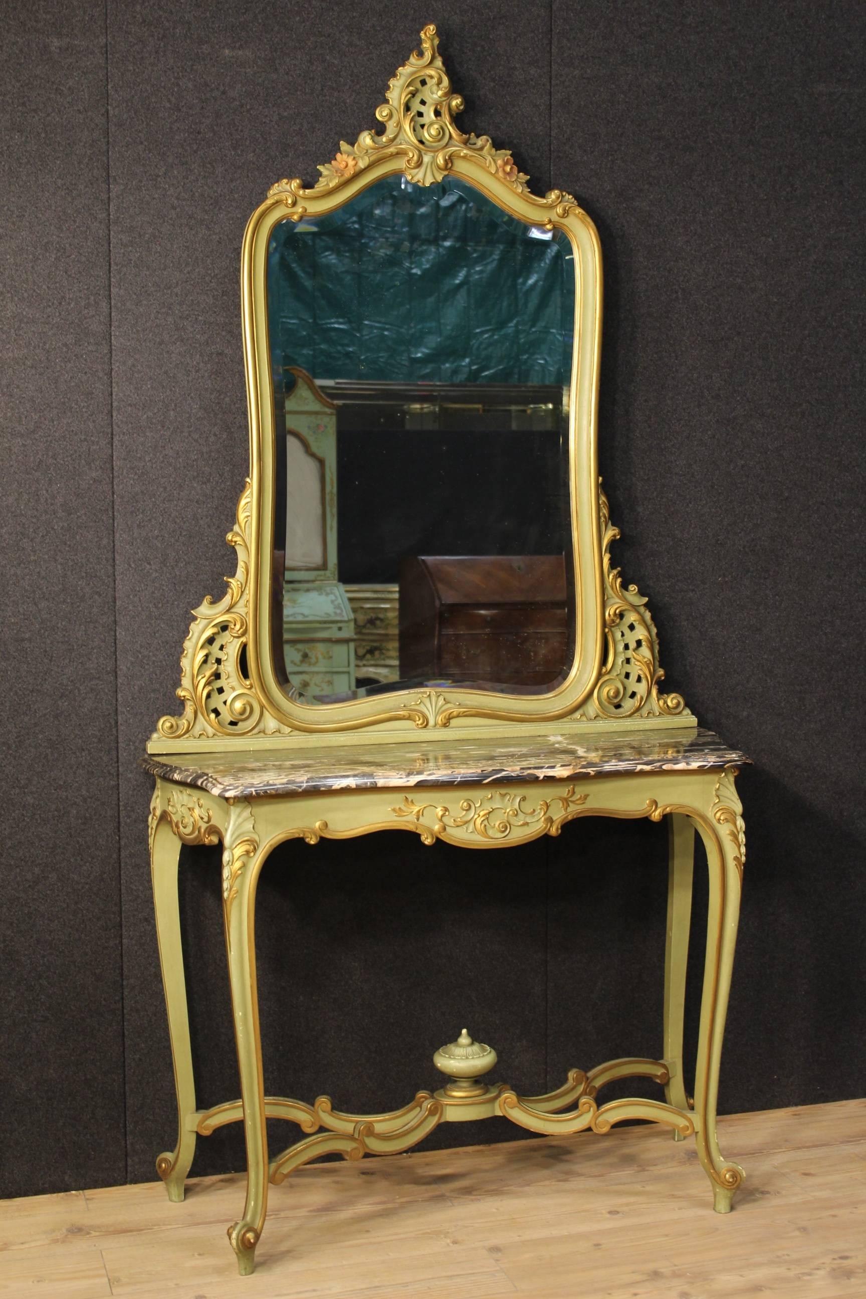 Console table with Italian mirror of the 20th century. Furniture in ornately carved, lacquered and golden wood. Console table with four legs with top in marble. Original mirror in perfect conditions. In good conditions, with some little falls of