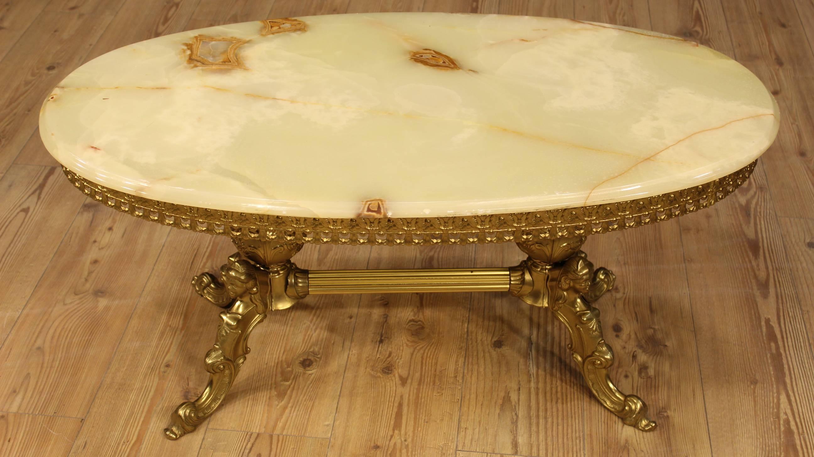 French coffee table of the 20th century. Chiseled and gilt furniture in brass. Oval top in onyx. Table ideal to be placed in a living room or study. In good condition with some small sign of the time.