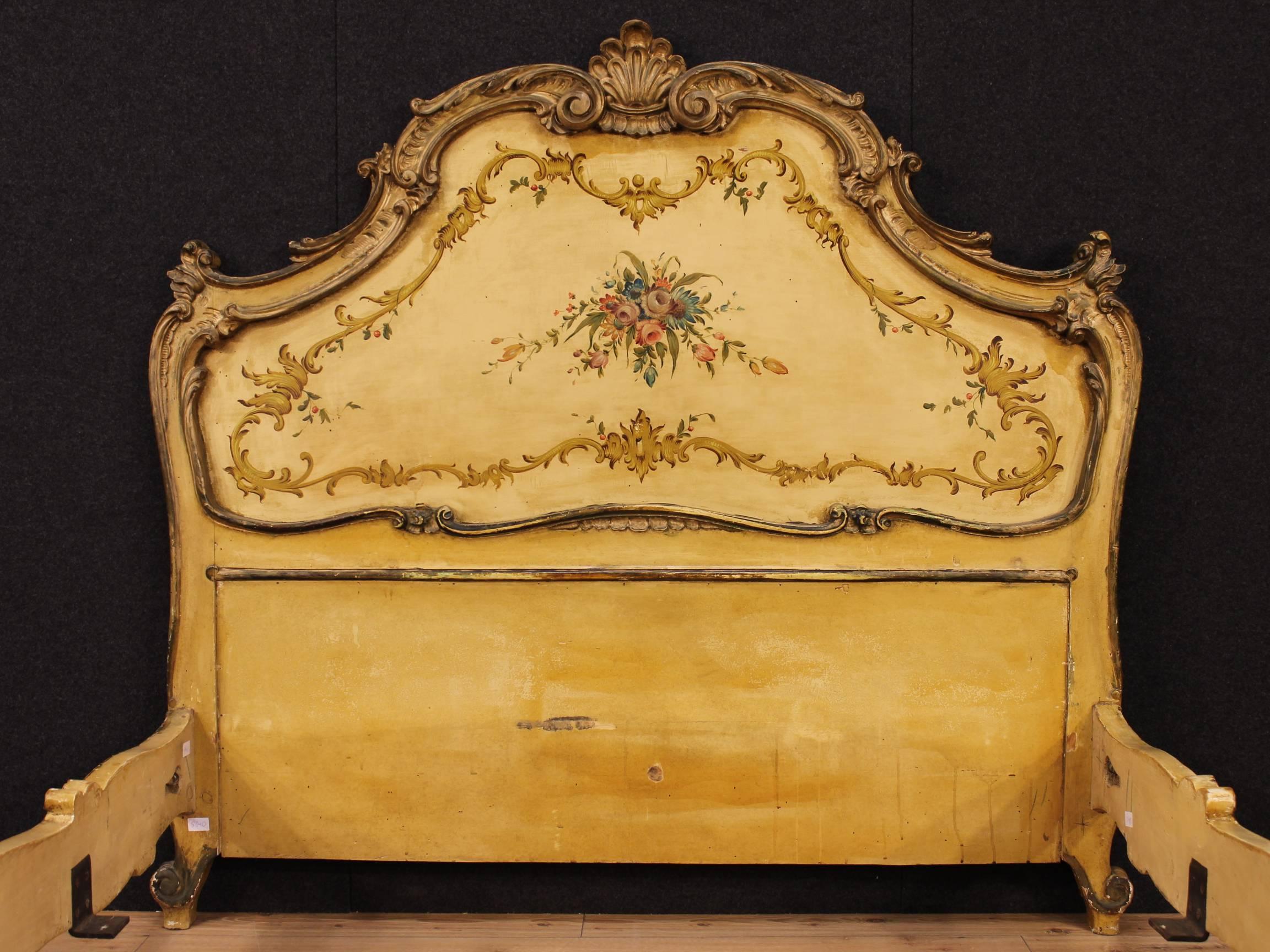 Spectacular Venetian bed of the 20th century. Furniture made by carved, gilded, lacquered and hand-painted with floral decorations wood. Queen-size bed nicely decorated with curled sculptures. Finished and decorated on three sides furniture, bed