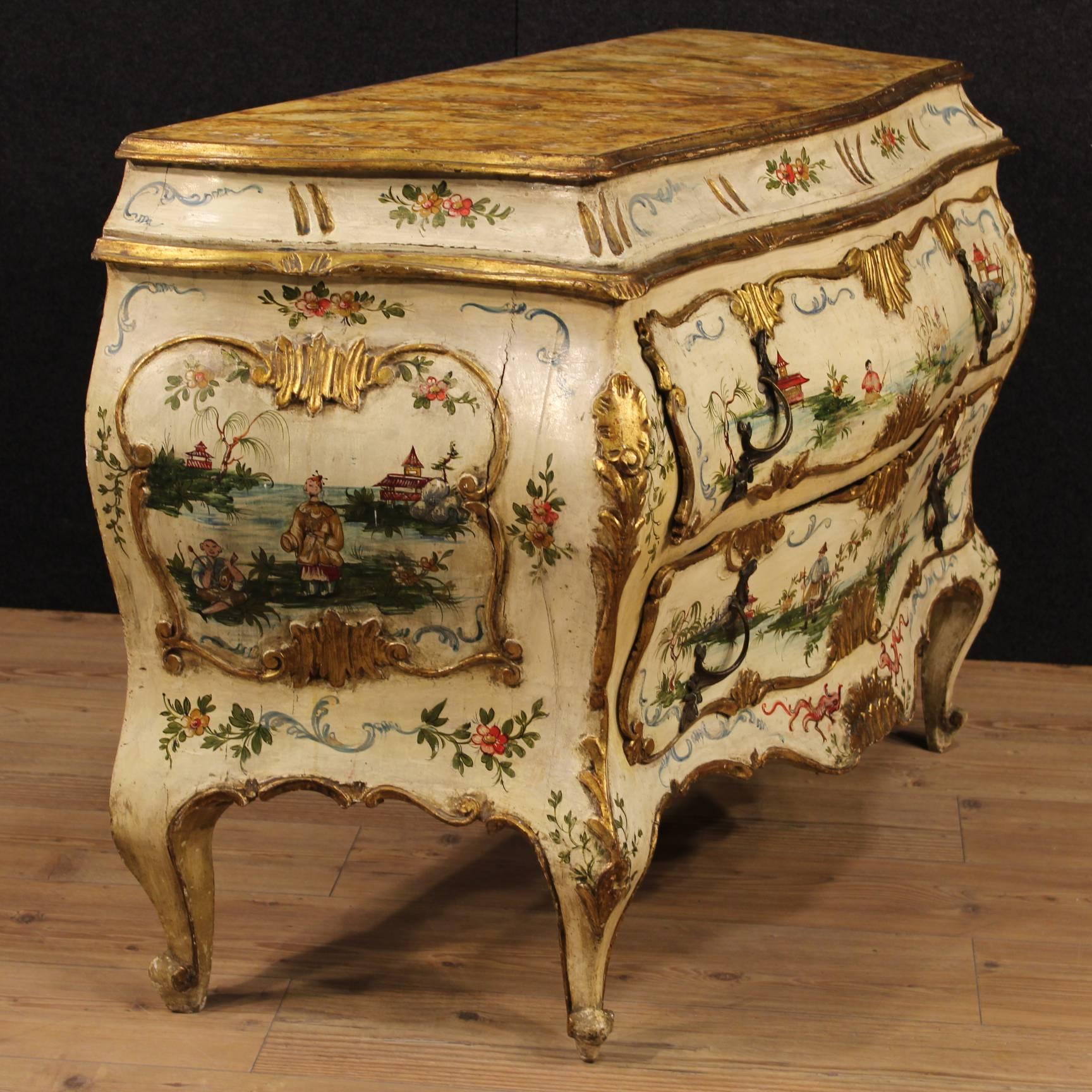 Venetian chinoiserie gilt and lacquered dresser. Chest of drawers made by carved wood and hand-painted with floral motifs and oriental style characters and landscapes. Furniture moved and curved of the 20th century of excellent quality and great