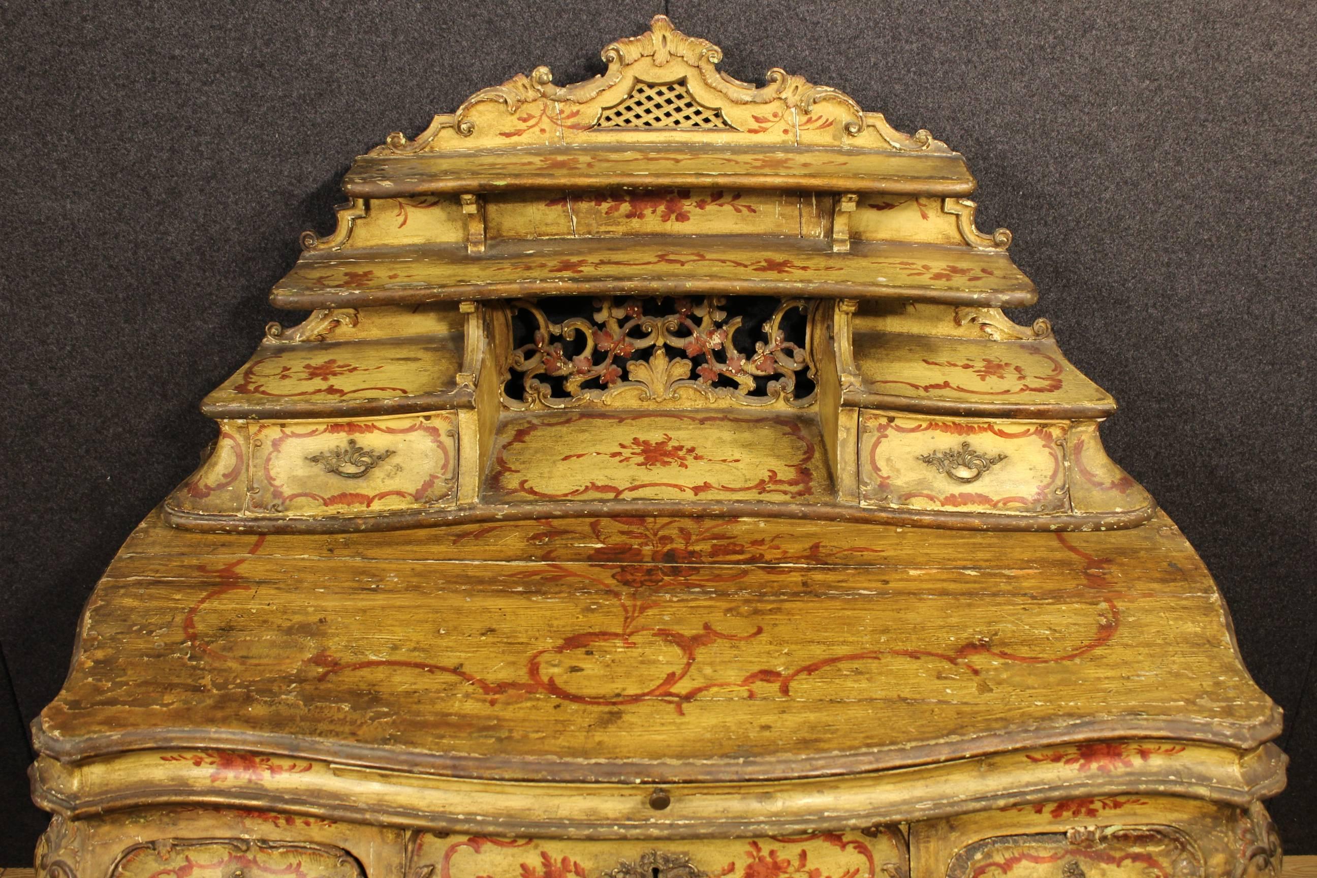 Spectacular Venetian writing desk of the late 19th century. Furniture ornately carved lacquered and painted with floral motifs of great taste, in fabulous patina. Desk finished from center built in two separable bodies (writing and shelf) of amazing