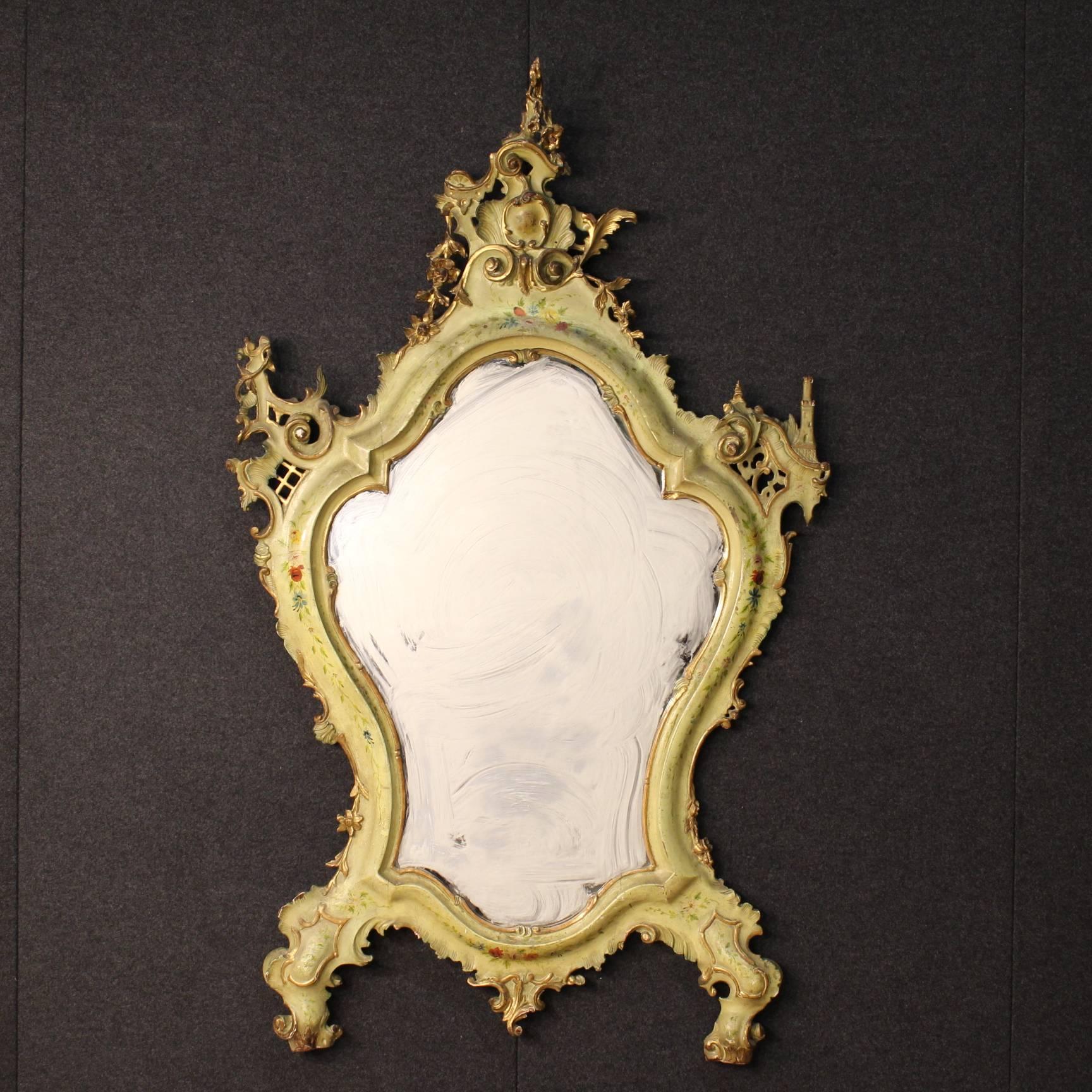 Big Venetian mirror of the second half of the 19th century. Furniture finely carved, gilded, lacquered and hand-painted with floral motifs. Rare mirror even for the special asymmetrical construction: note the sculpture of a castle at the top right.