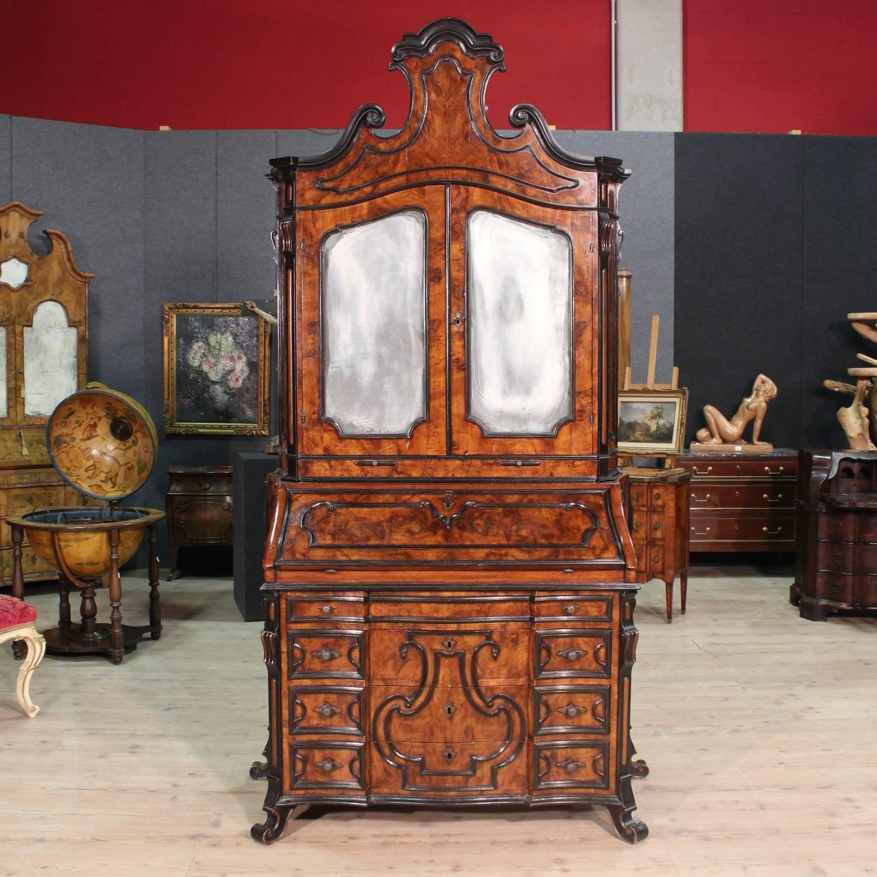 Bureau from Milan of the late 19th century. Double body furniture richly carved in walnut and burl walnut with ebonized decorations of great quality and impact. Bureau with moved front with countersink sides of fabulous line ideal for a living room