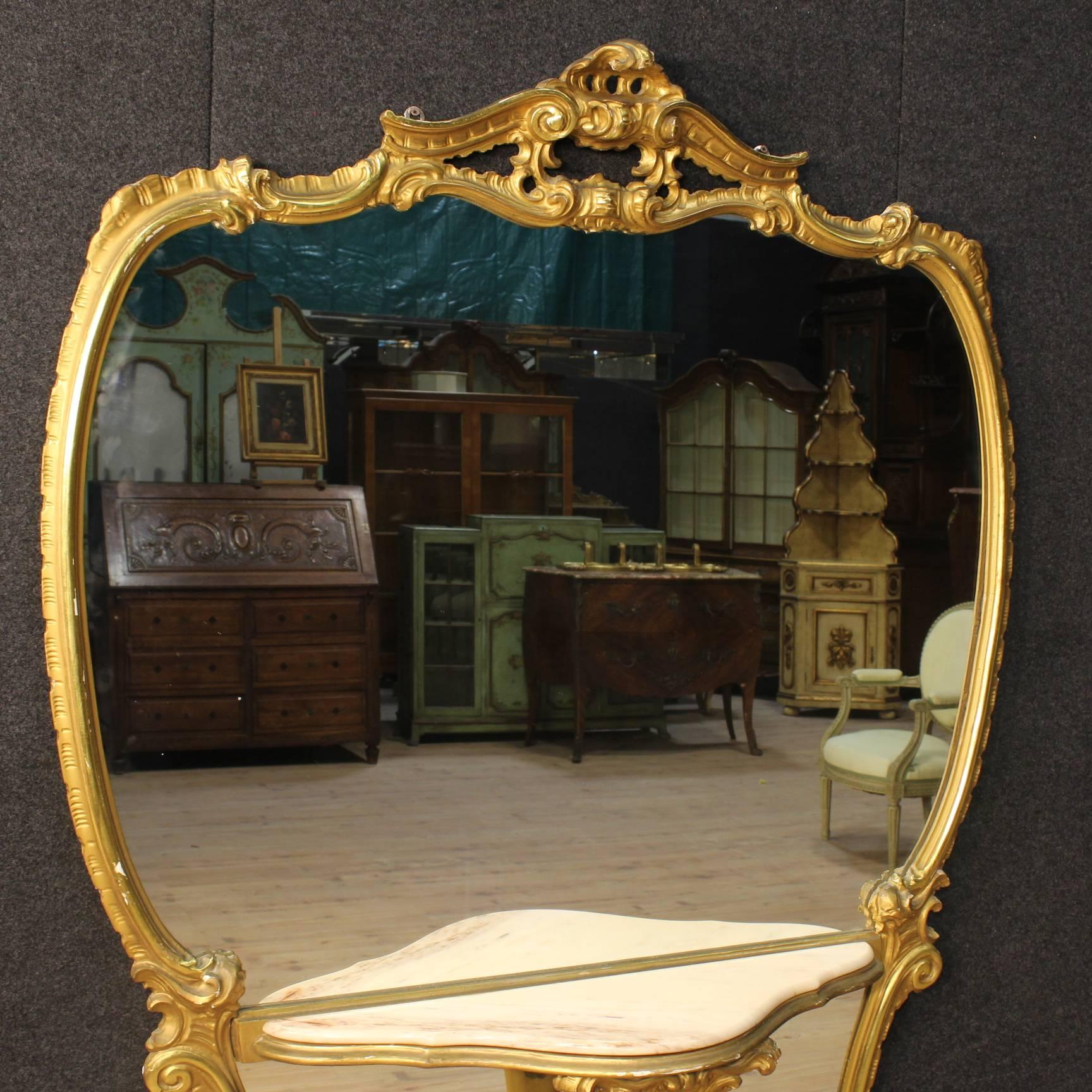 Great 20th century Italian cheval mirror. Furniture made by ornately carved and gilded wood of great impact and beautiful decoration. Cheval mirror resting on three feet equipped with a console table with top in onyx and recessed mirrors. Furniture