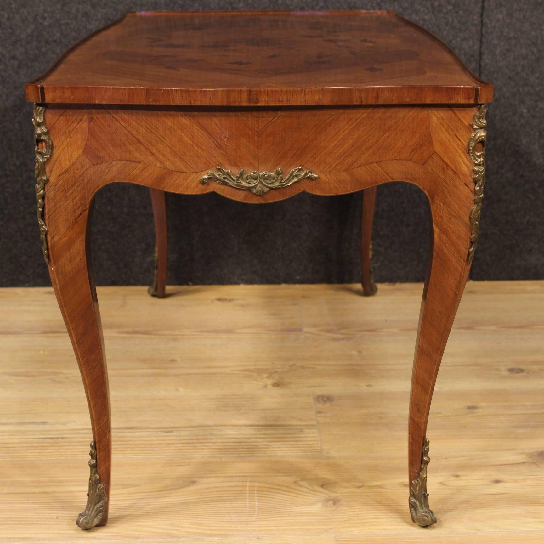 French coffee table of the 20th century. Coffee table in rosewood and palisander finely inlaid on the top floor with floral motifs. Furniture decorated with chiseled bronzes of beautiful line. Coffee table of high proportion, in good condition, with