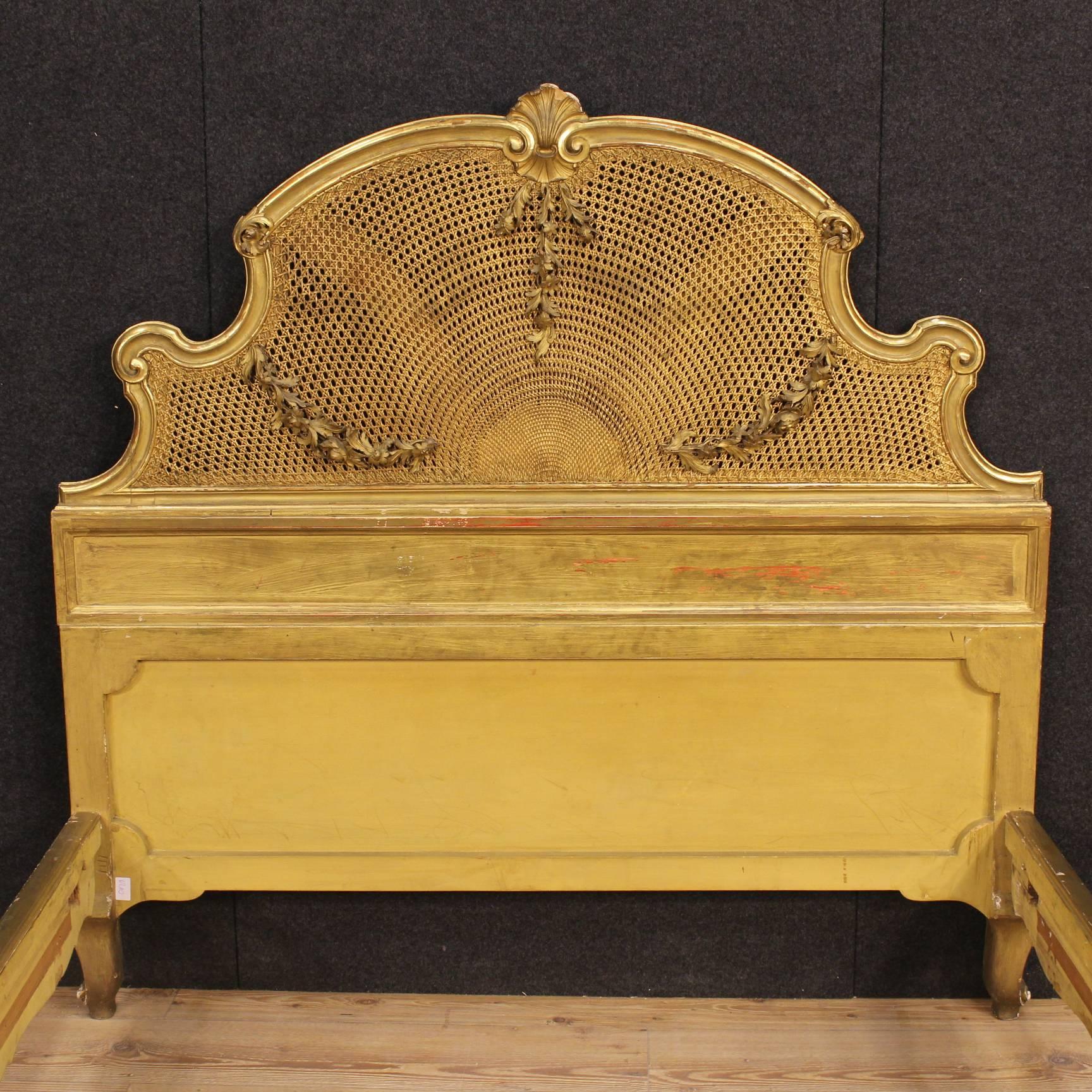 Scenic queen-size bed, Italy of the 20th century. Furniture of great taste and beautiful decoration made by ornately carved and gilded wood. Bed decorated on the headboard and footboard with golden Vienna straw also in good condition. Furniture