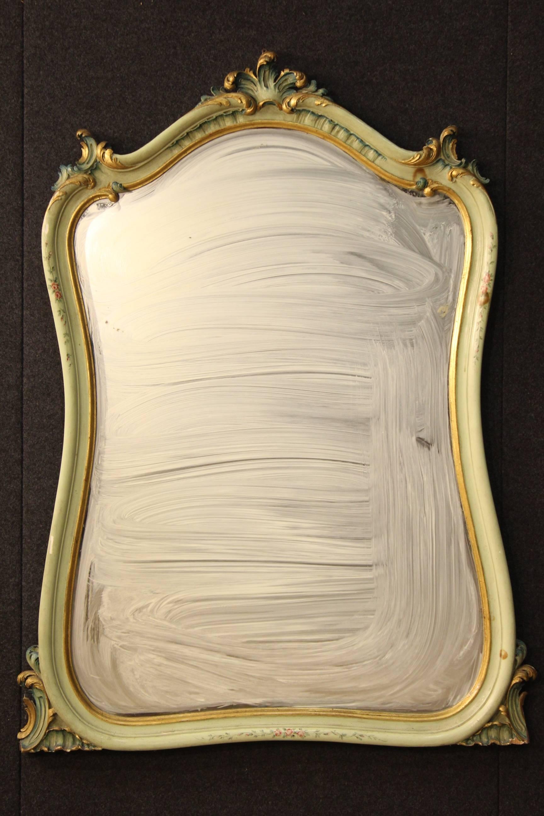 Big Venetian mirror in finely carved, gilded and hand-painted with floral motifs wood. Furniture of the 20th century of decoration large, that can be easily inserted into different parts of the house. It has some paint drops and deficiencies in the