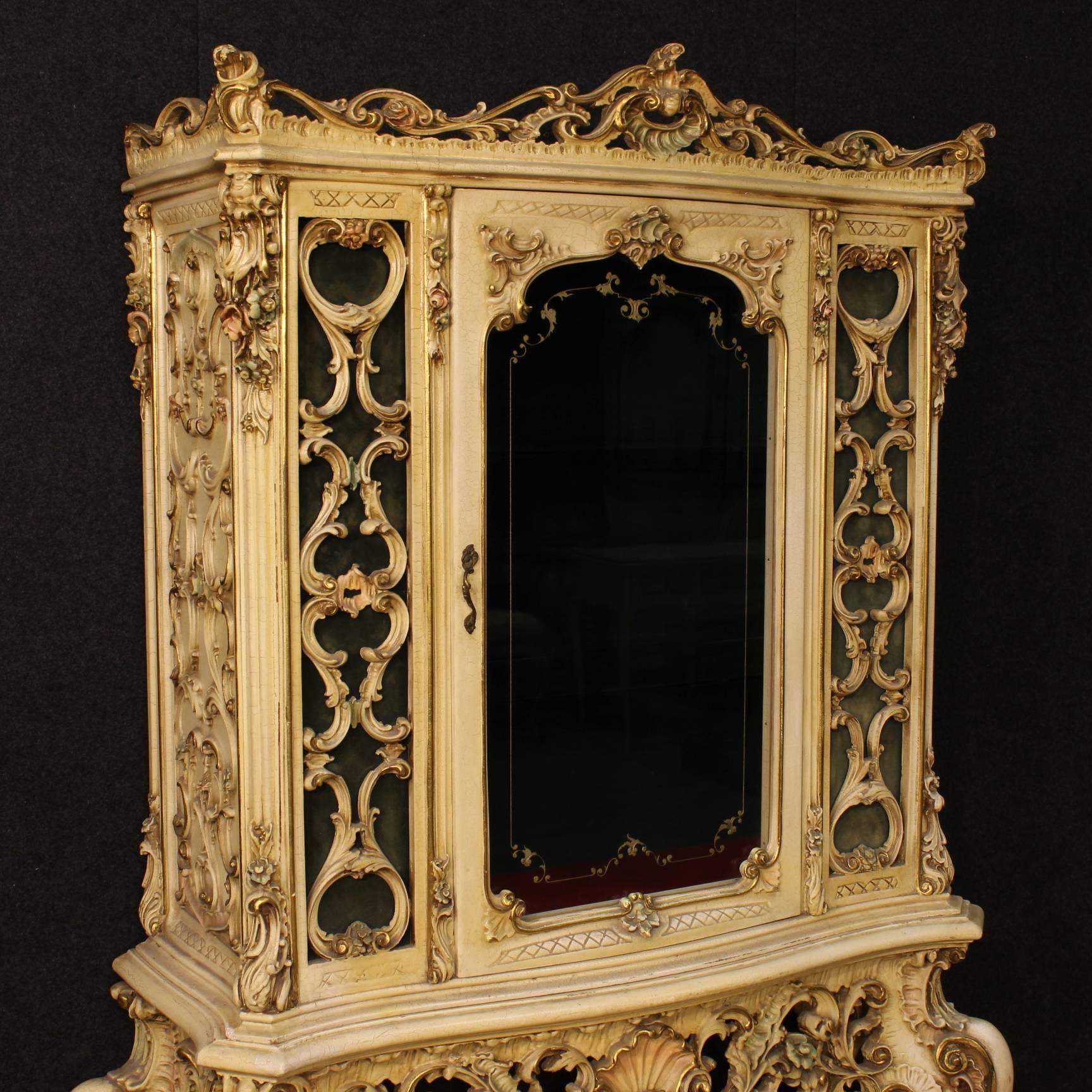 Scenic Venetian showcase of the late 20th century. Furniture made by lacquered, gilded and painted pressed wood and plaster of fabulous decoration. Double body furniture composed of a console and a showcase with one door, it is separable for easy