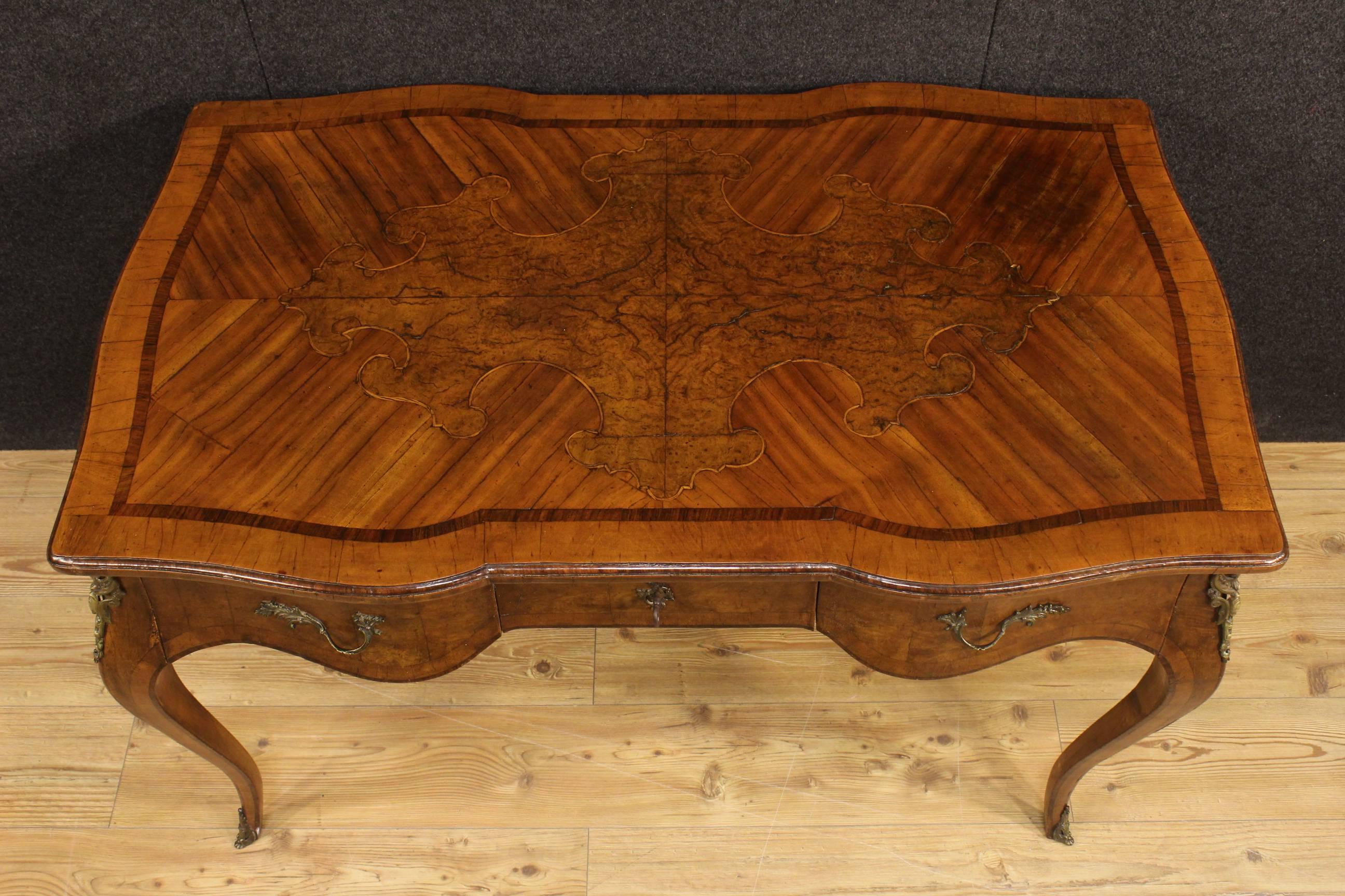 Elegant Italian desk of the 20th century. Furniture moved and curved nicely inlaid in walnut, boxwood, rosewood and burl of great quality. Desk finished for the center, it has three frontal drawers of good ability with writing top in character of