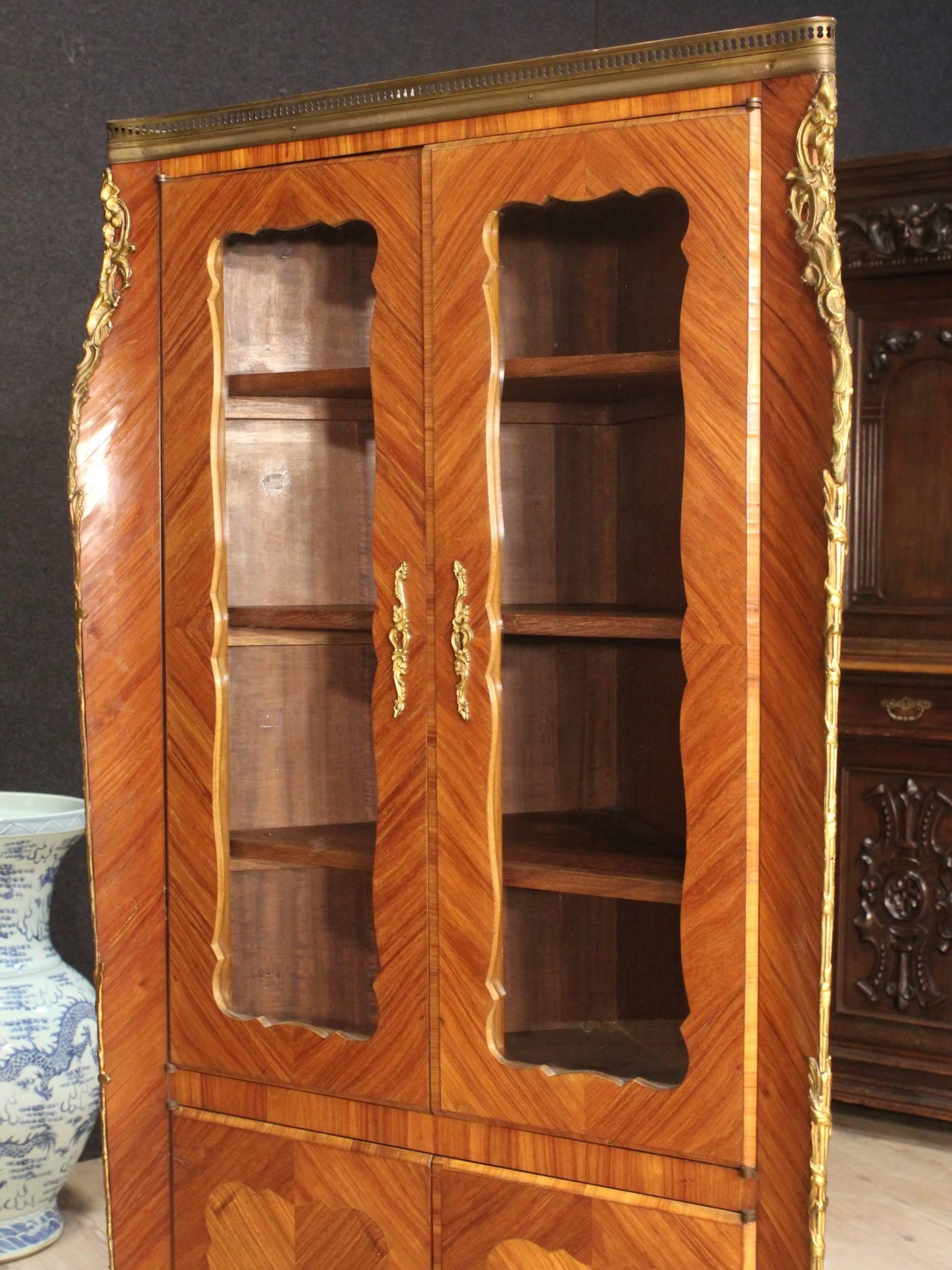 Stylish French corner cupboard of the 20th century. Furniture in rosewood richly adorned with gilded and chiseled bronze of beautiful line and good taste. Corner cupboard with four doors complete with a working key. Furniture built in one body that