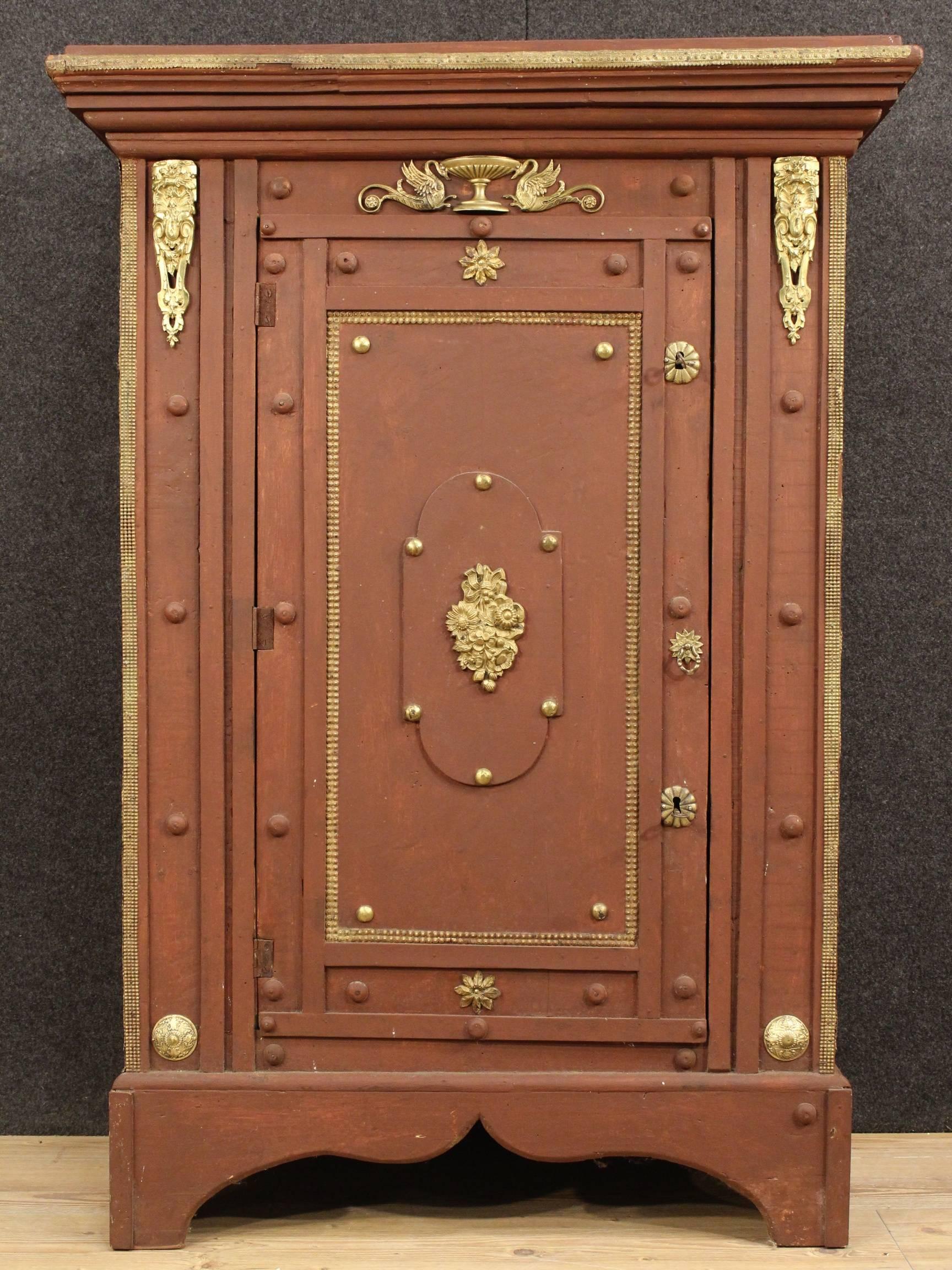 Particular Italian cabinet of the 20th century. Furniture in nicely carved and painted wood, richly decorated with gilt and chiseled brass. Cabinet 