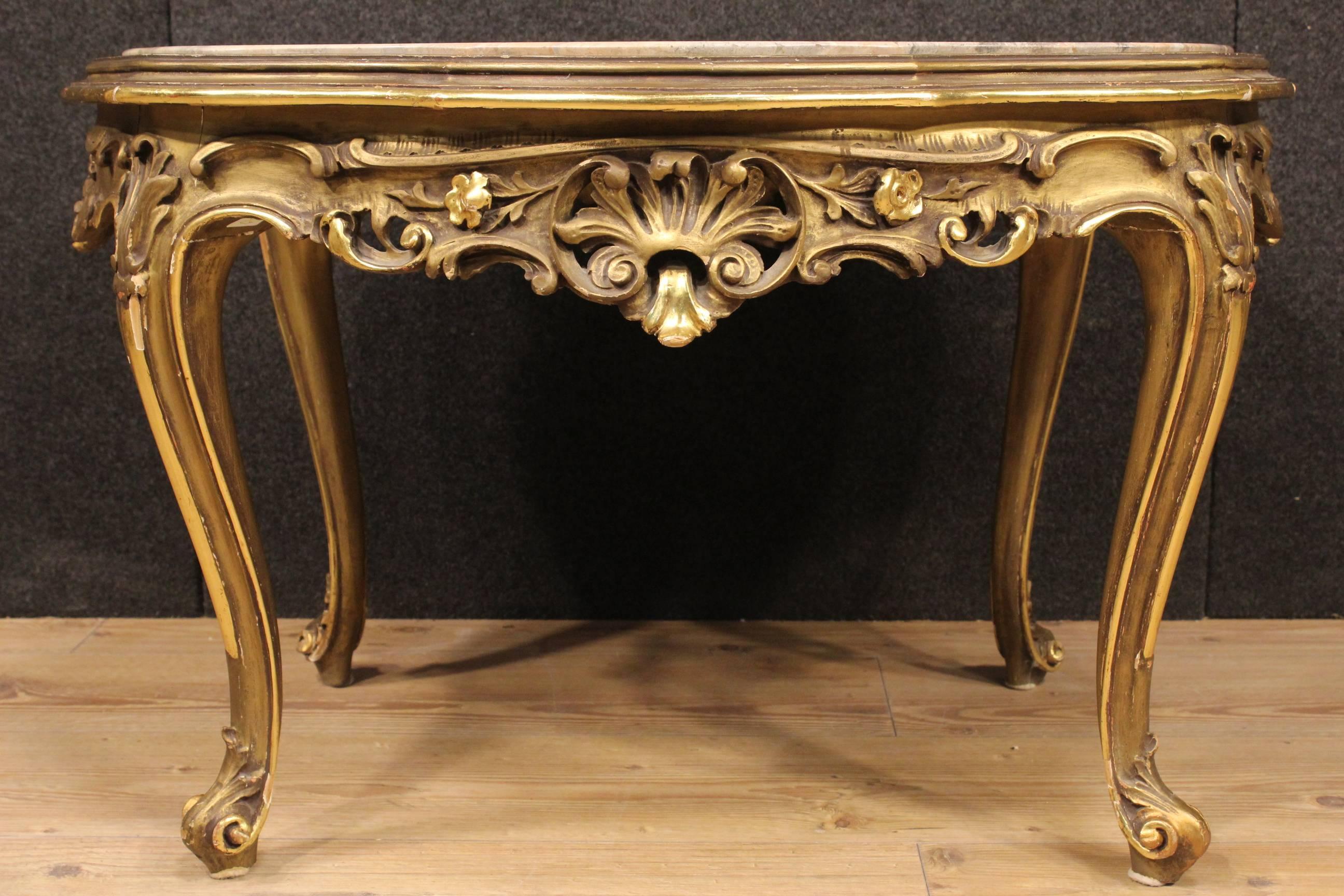 Italian coffee table in richly carved and gilded wood of great quality and pleasantness. Furniture of the 20th century of excellent proportions, ideal to be included in a living room but it can easily be inserted at different points of the house.