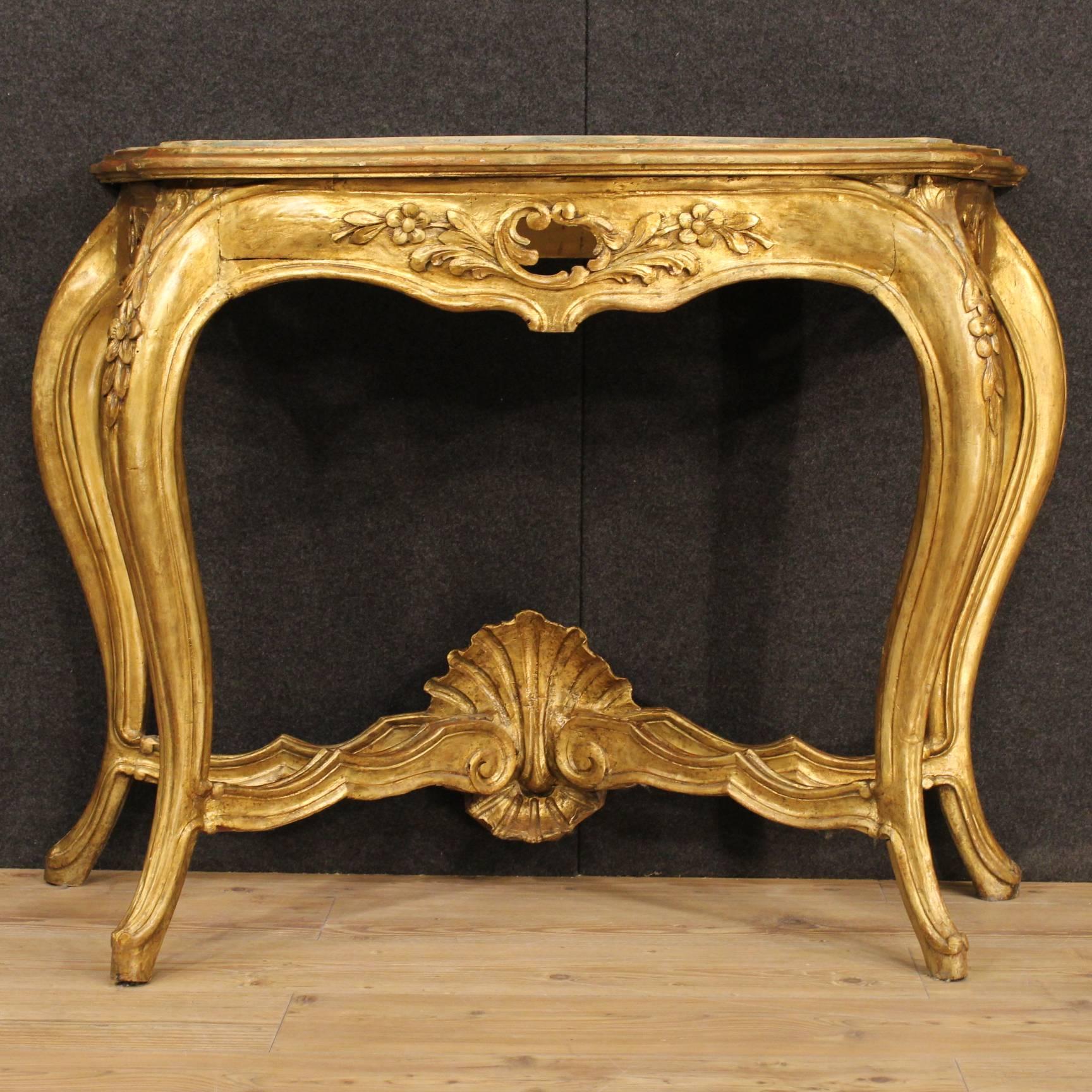 French console table in finely carved, gilded and lacquered wood. Wall furniture with four legs of good stability, with top in lacquered faux marble wood. Console table of the 20th century of great decoration, perfect for a salon, but it can be