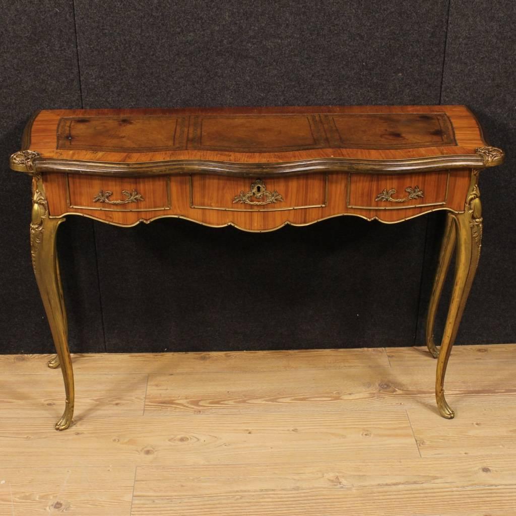 Particular French console table from the second half of the 20th century. Furniture in rosewood richly decorated with chiseled and gilt bronze and brass. Wall console table equipped with three frontal drawers of discrete capacity, top in character